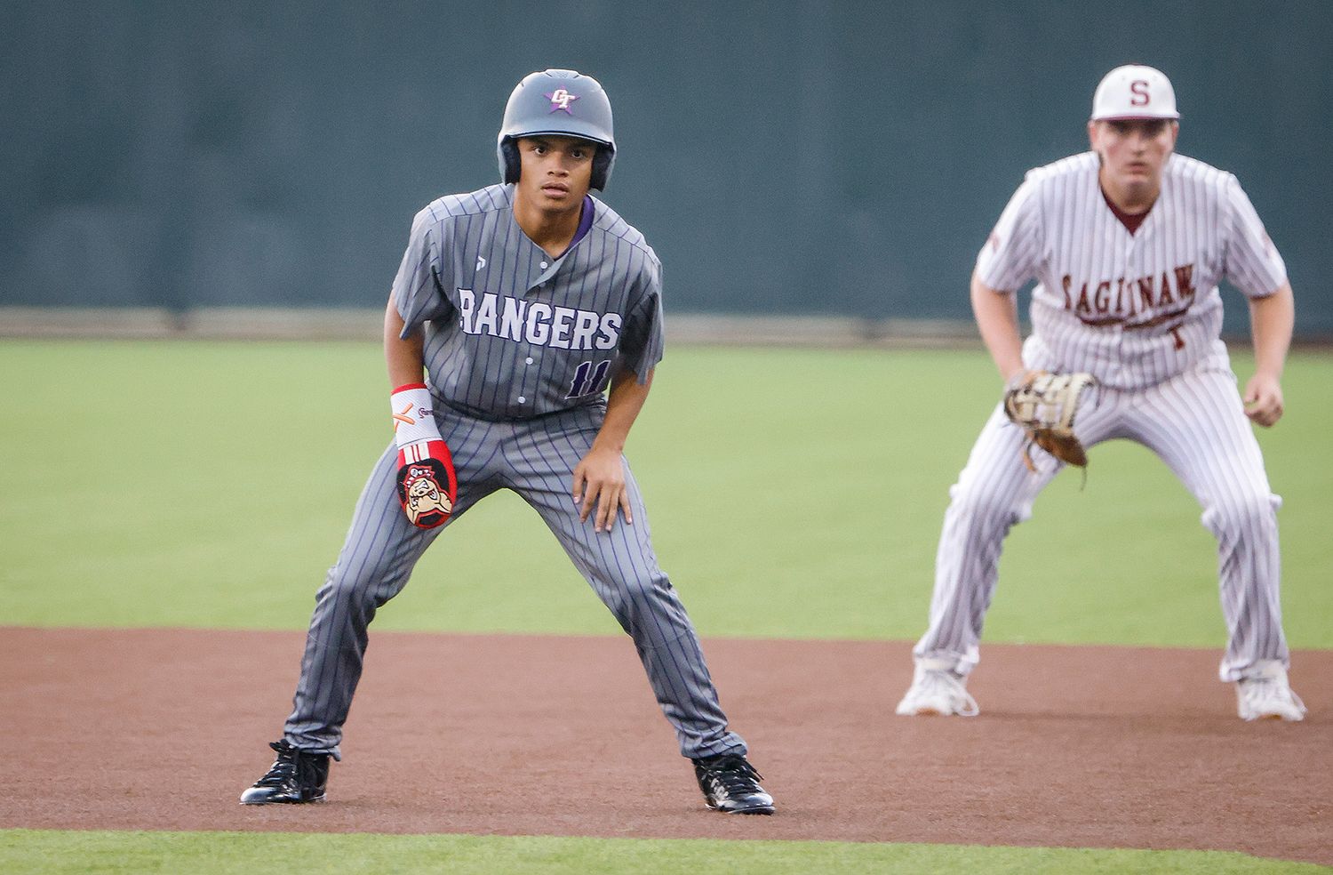 Two baseball players in Rangers and Saginaw uniforms in ready stance on field during a competitive game.