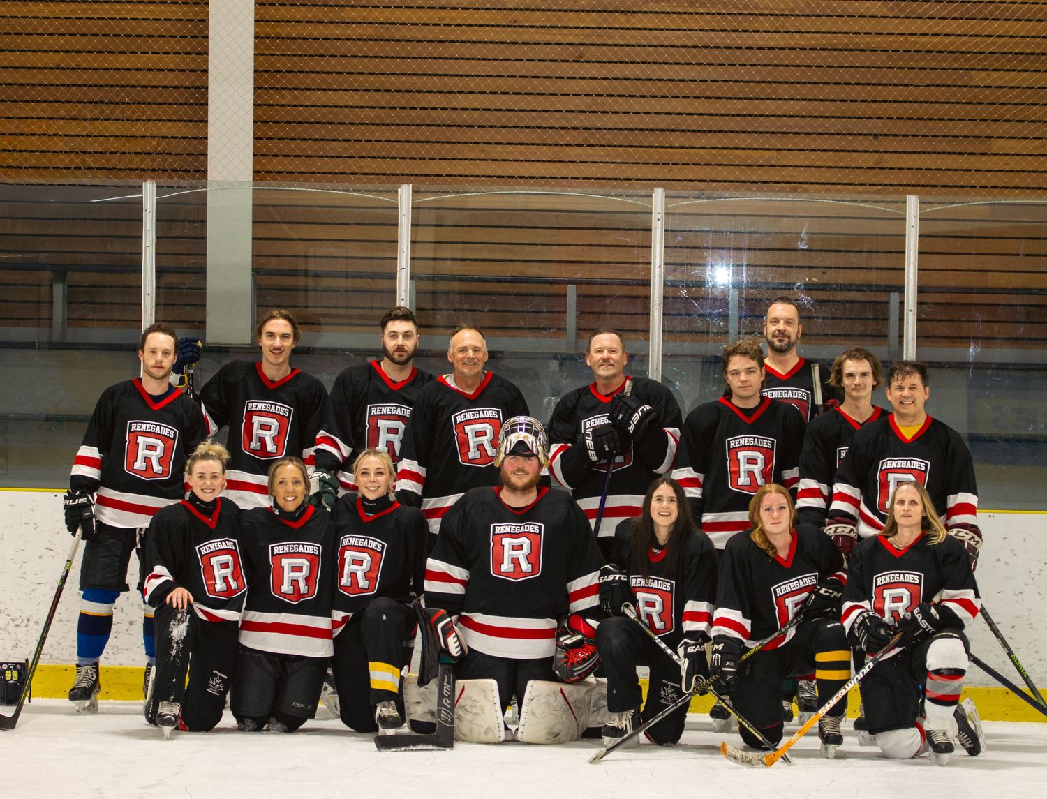 Renegades hockey team group photo on ice rink wearing black red and white jerseys.