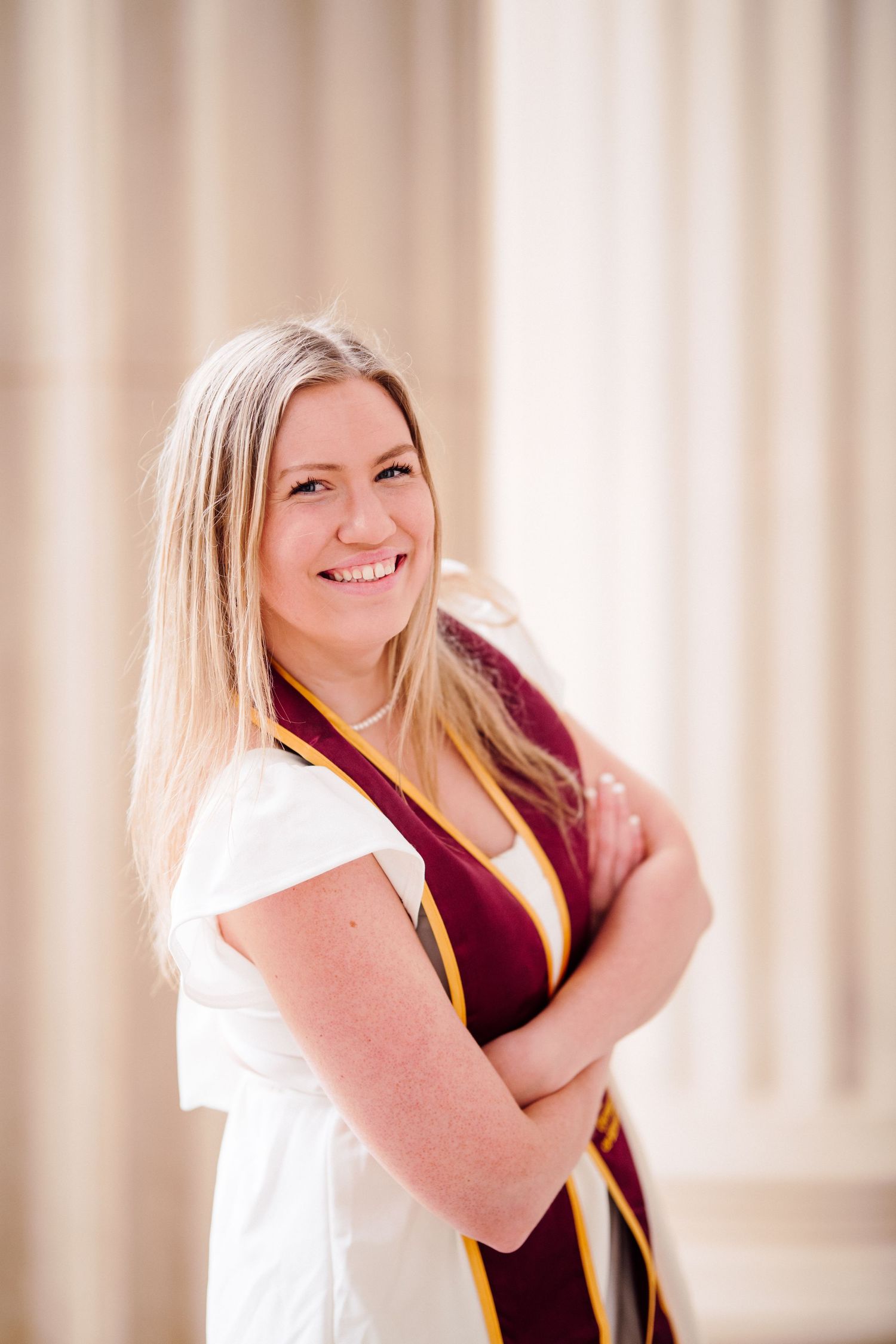 university of minnesota graduate in white dress with sash