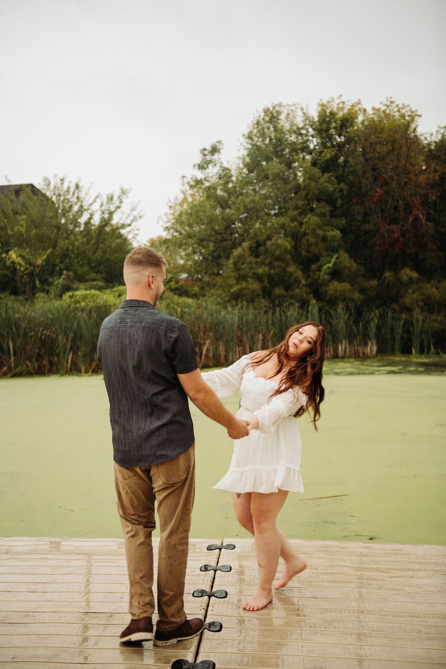 couple dancing in engagement pictures on dock