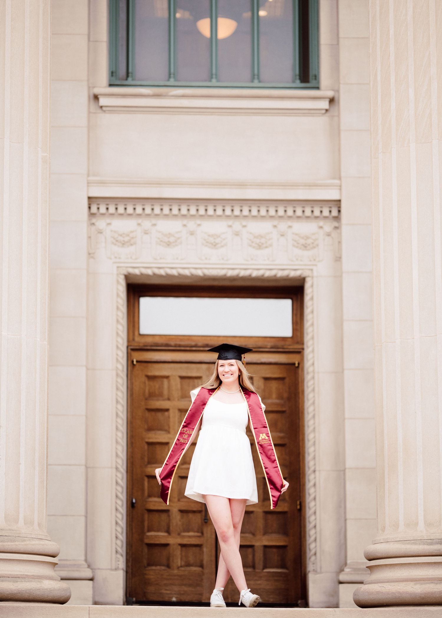 university of minnesota graduate in white dress with sash