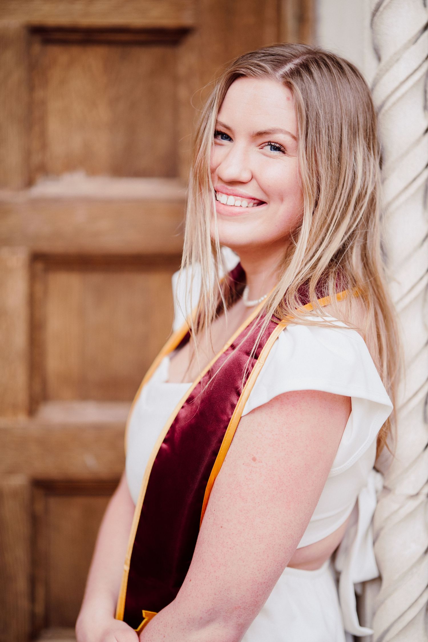 university of minnesota graduate in white dress with sash