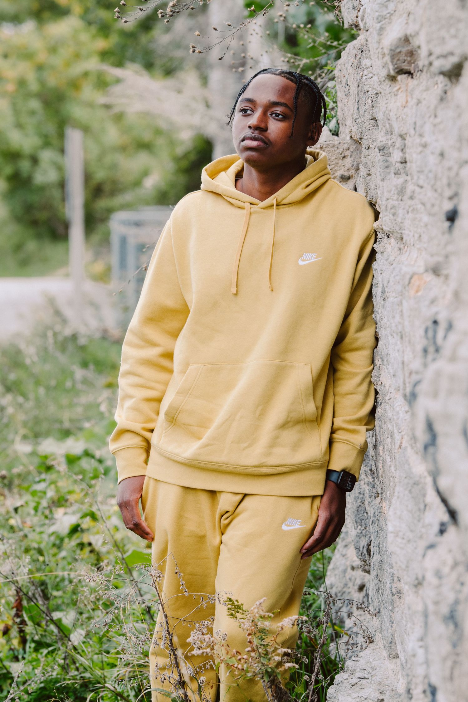 senior guy pictures in minneapolis leaning against wall