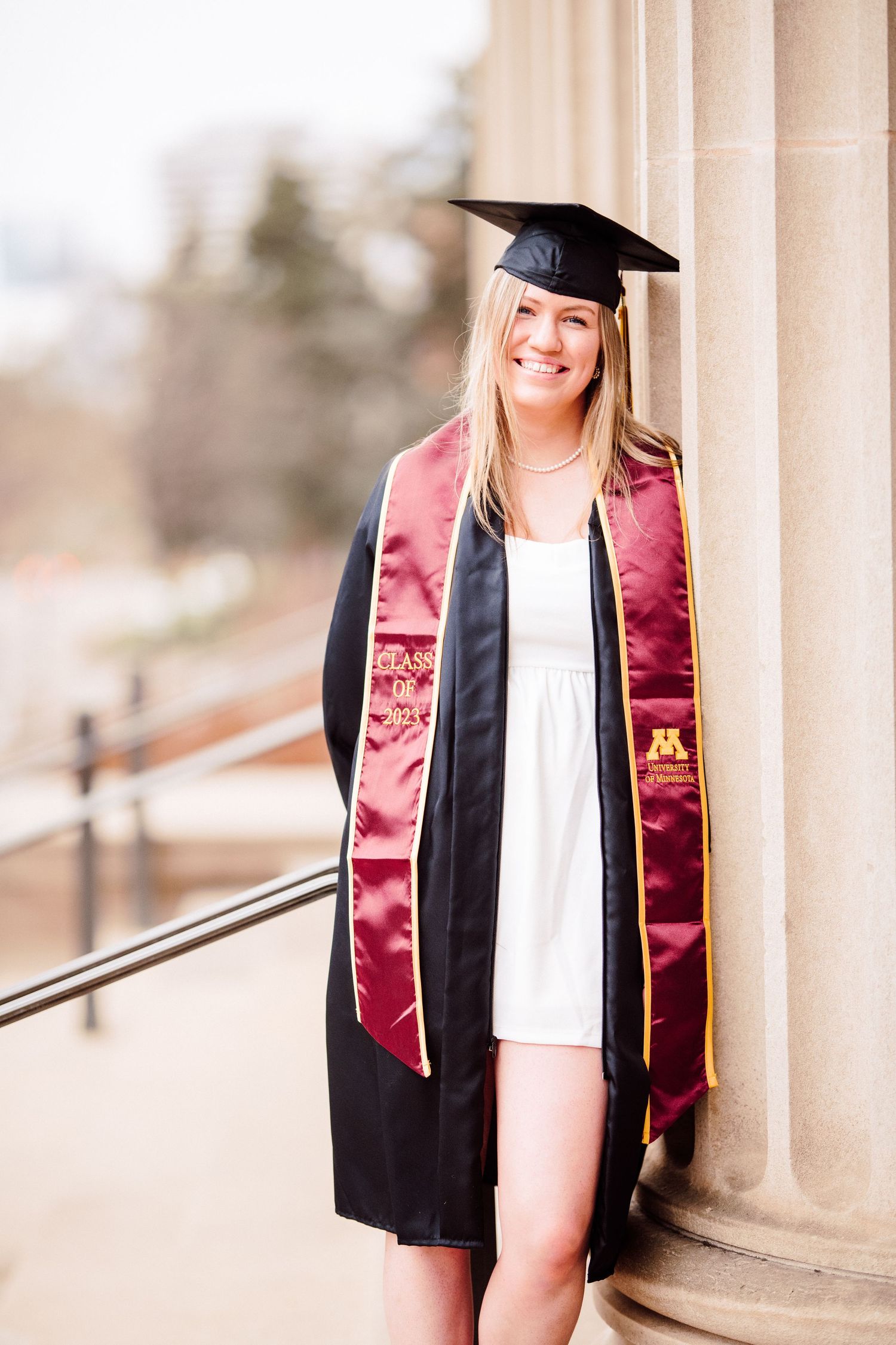 university of minnesota graduate in white dress with sash