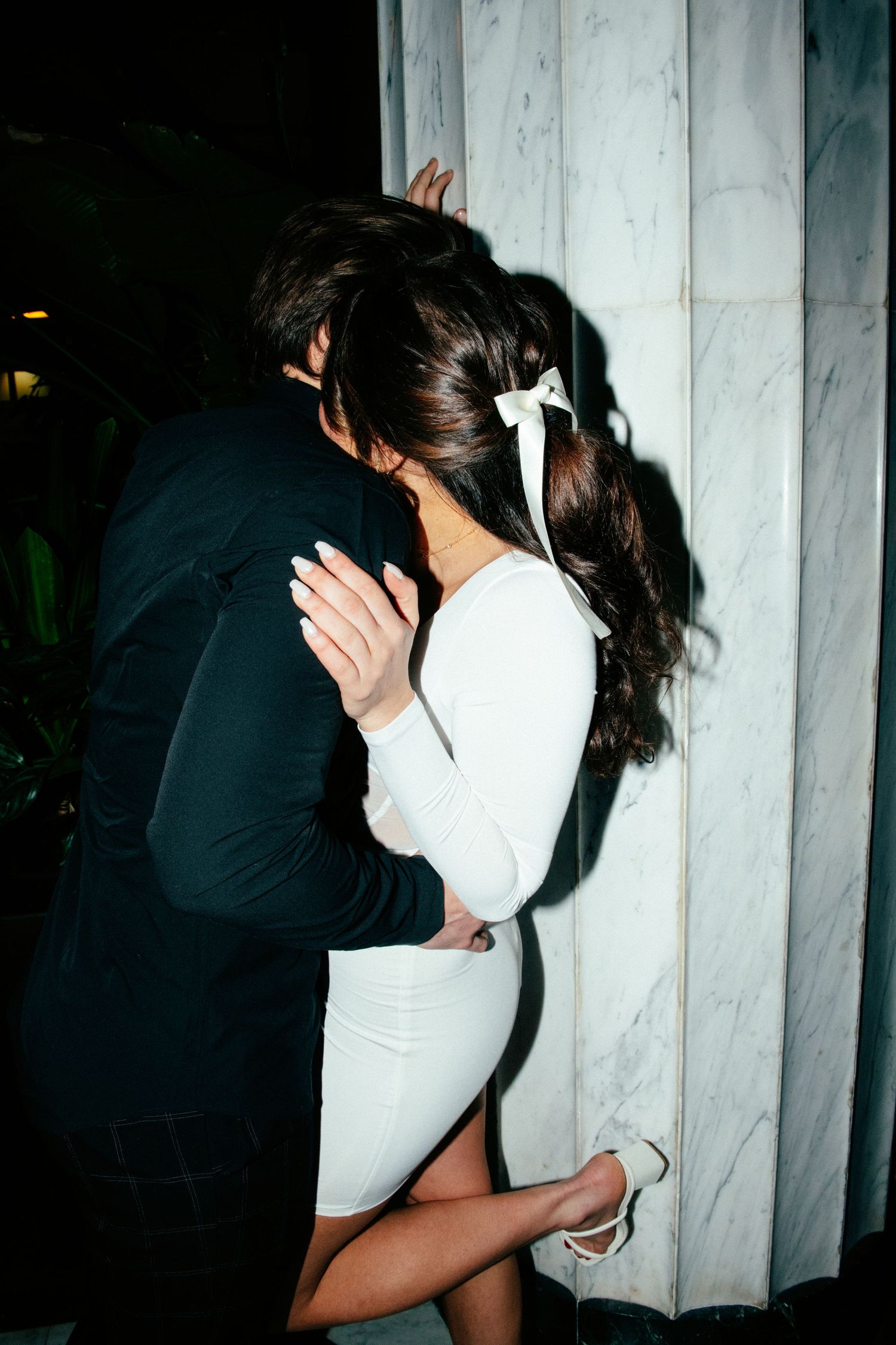 engagement photo of couple with direct flash in front of marble wall at hotel in minneapolis