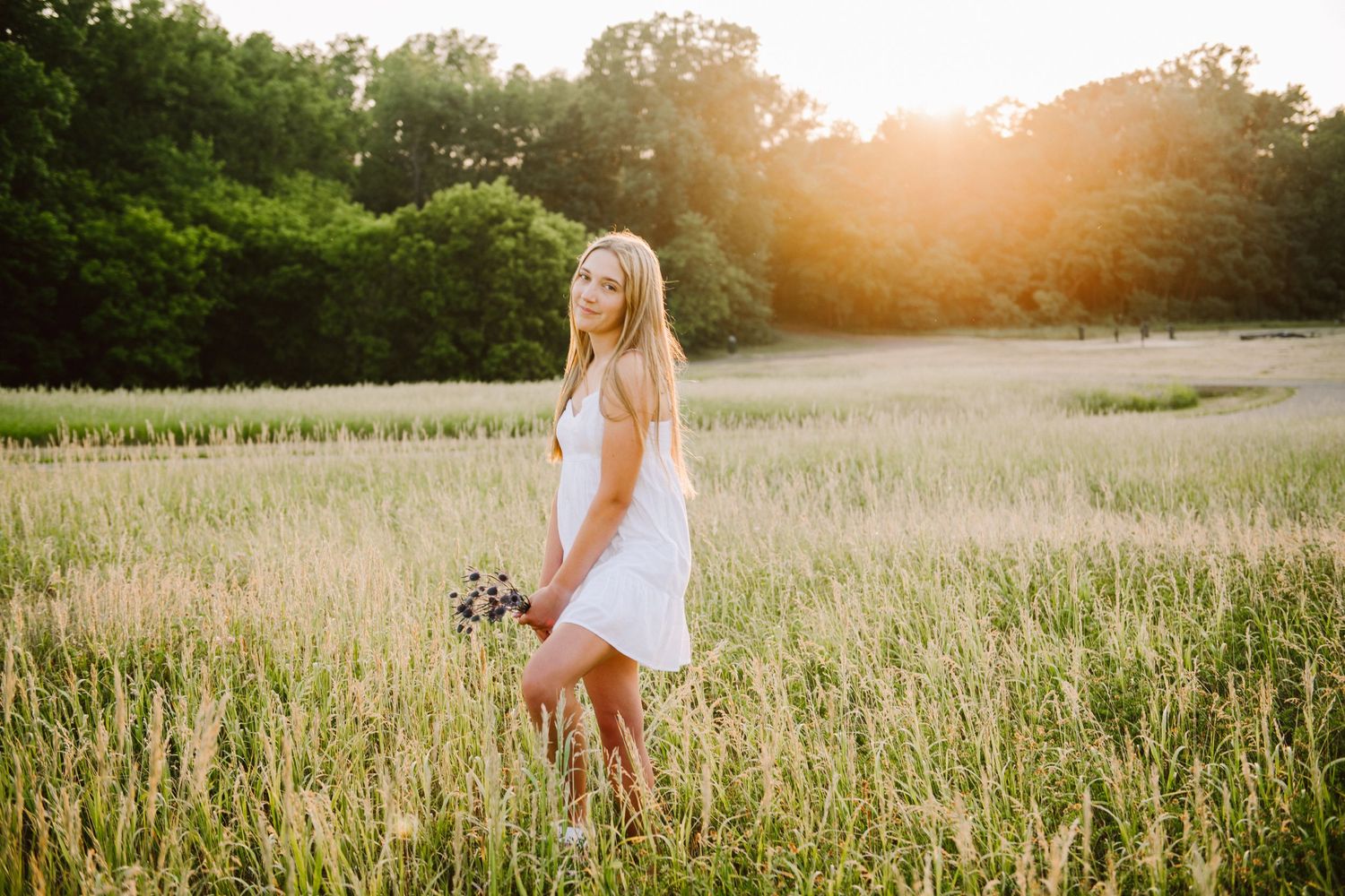 high school senior girl pictures in a field on a stool