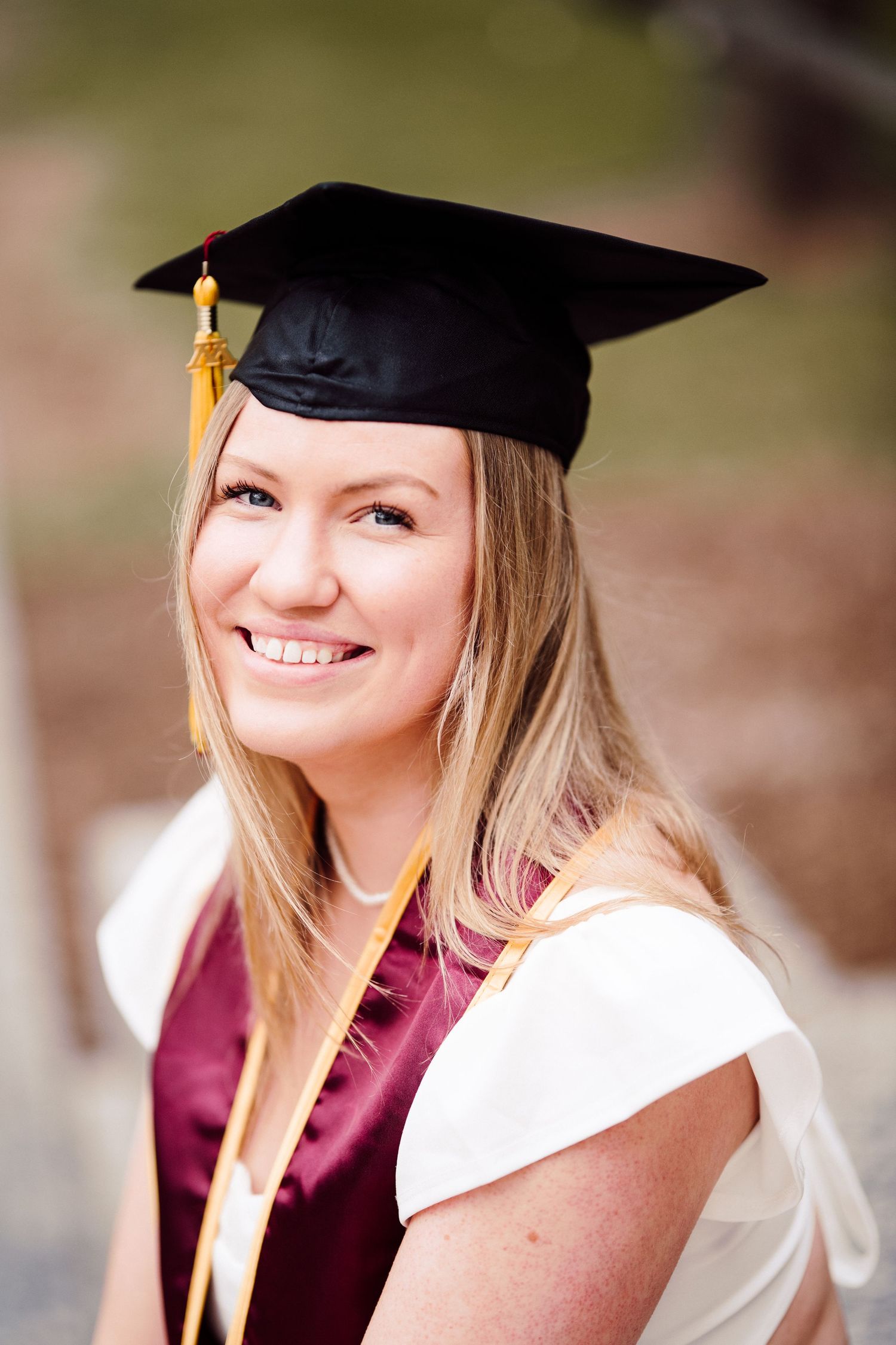 university of minnesota graduate in white dress with sash