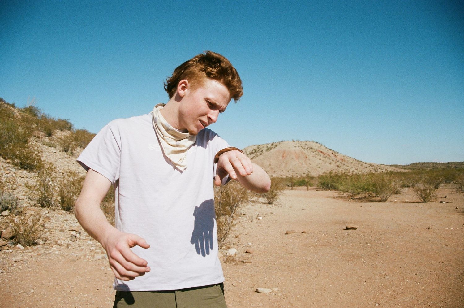 film photo of man holding a large millipede