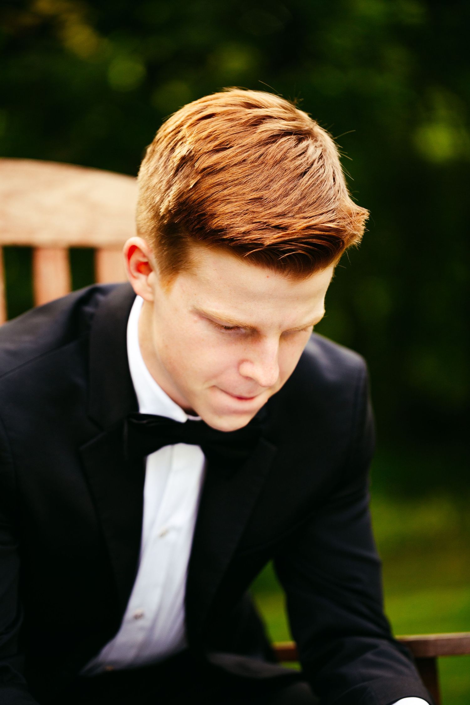 groom sitting in chair reading a letter