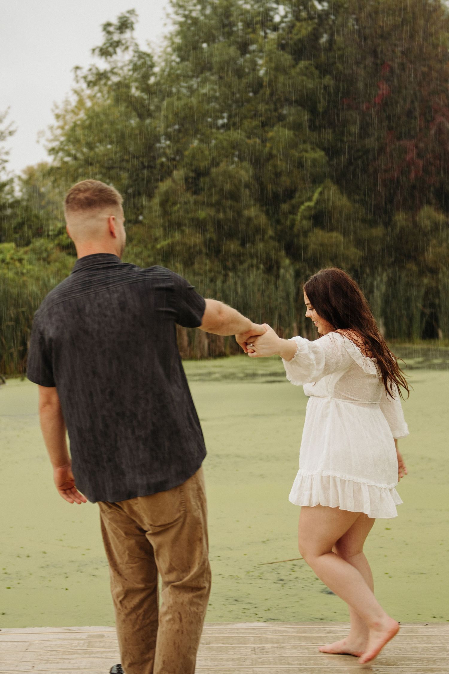 couple dancing in engagement pictures on dock