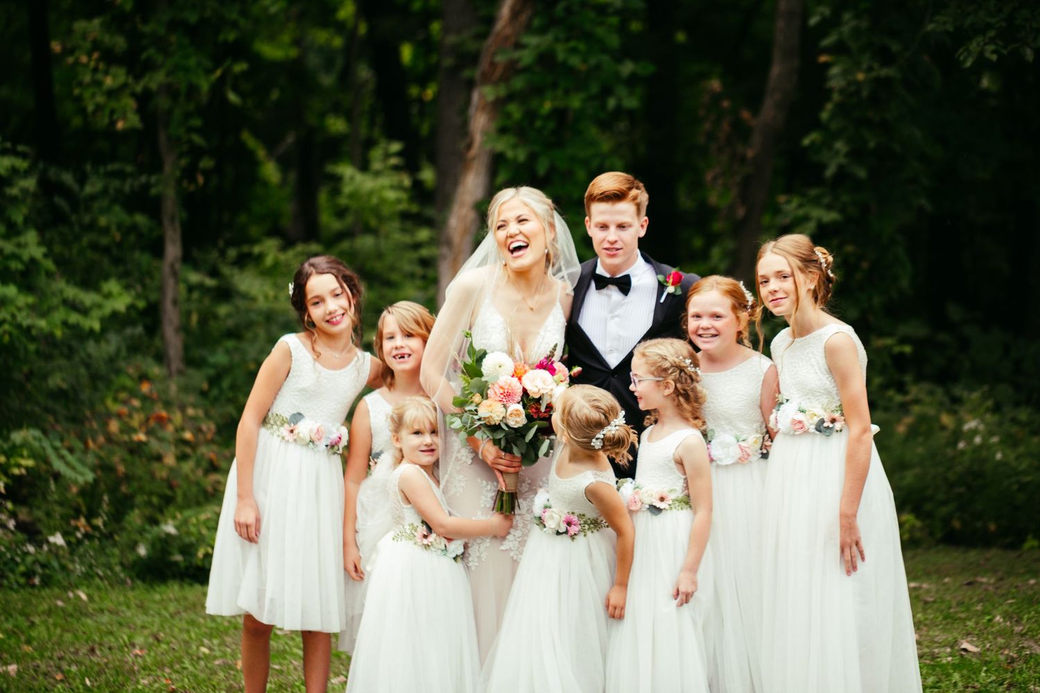 bride and groom picture with flower girls
