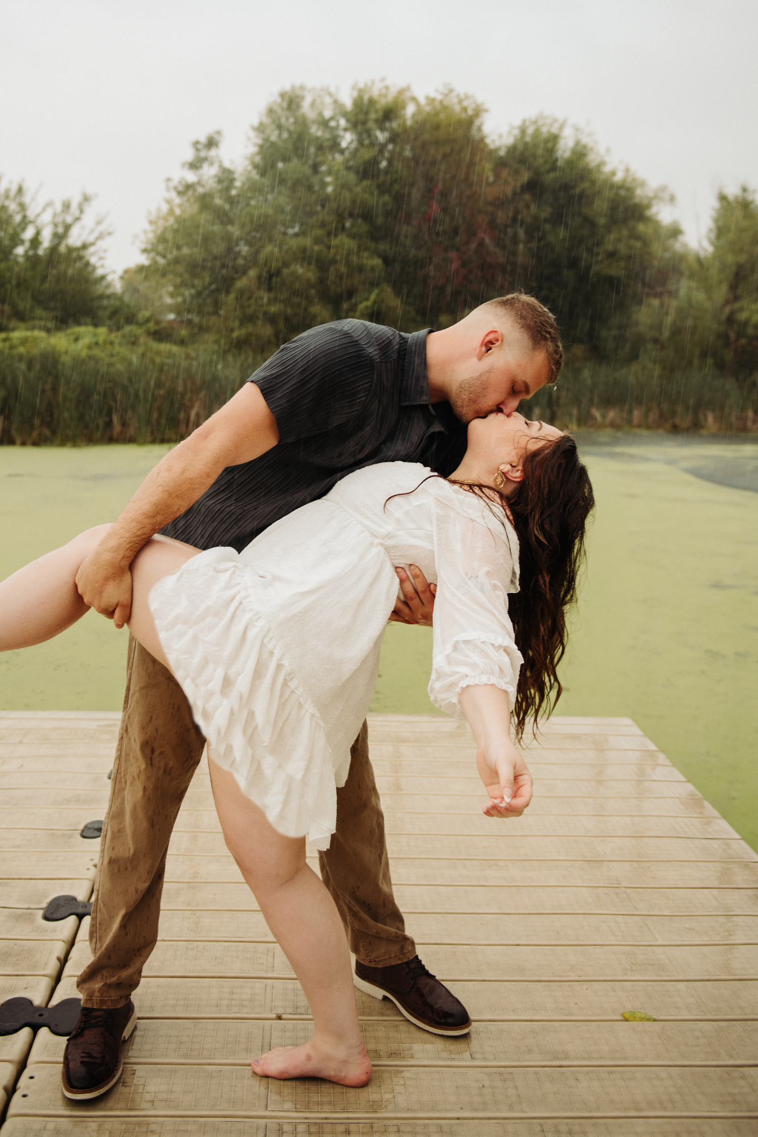 couple dancing in engagement pictures on dock