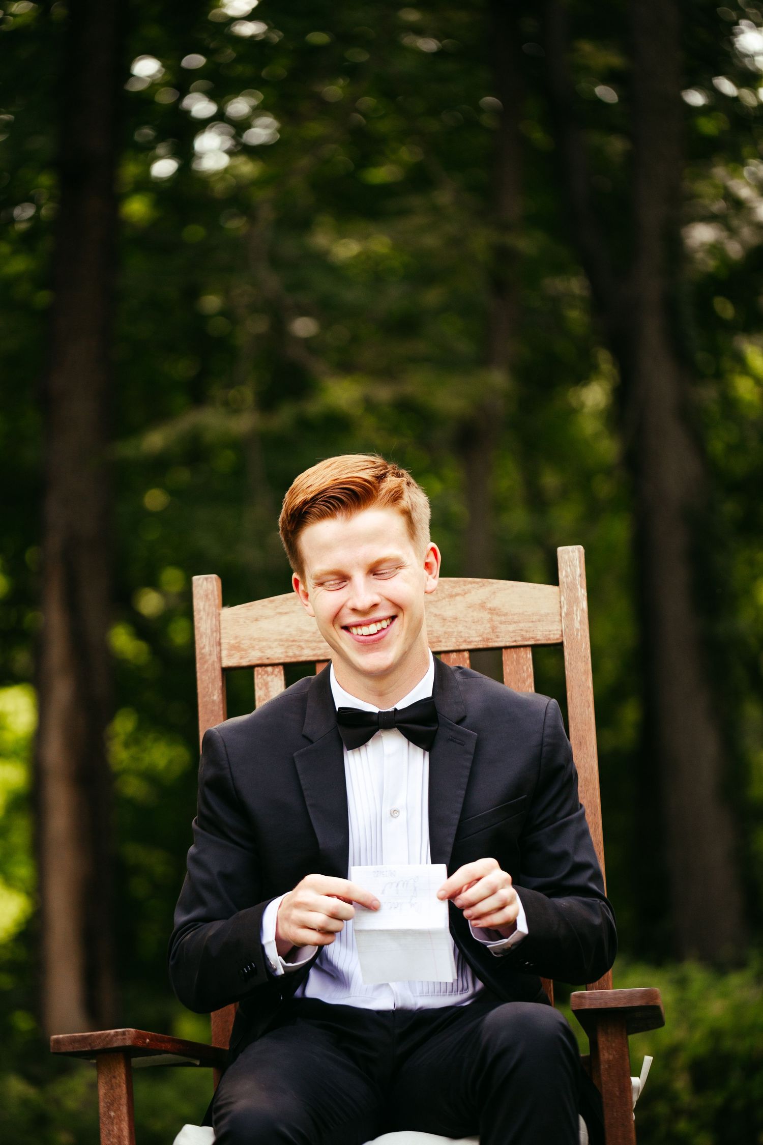 groom sitting in chair reading a letter
