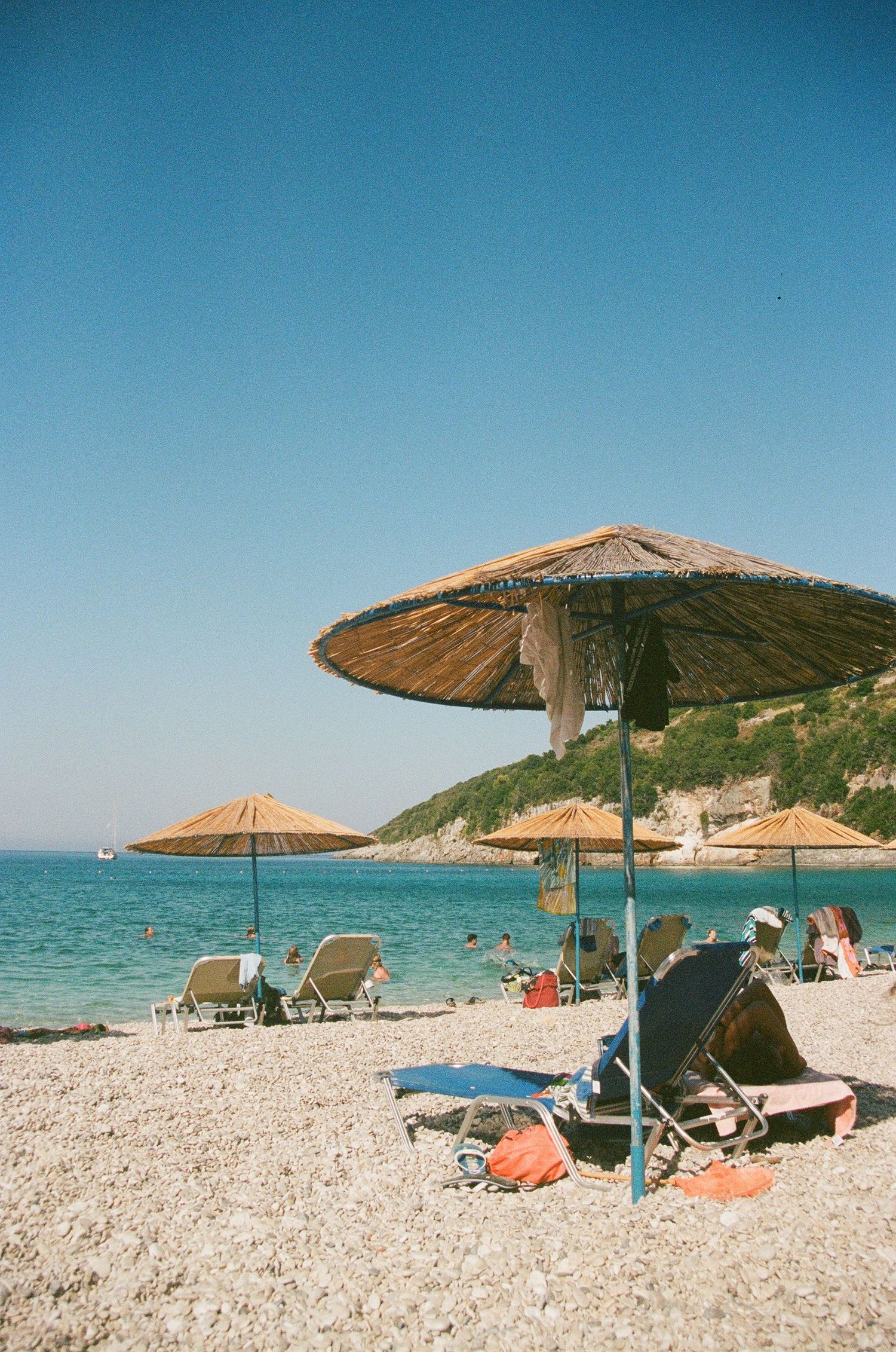 film photo of umbrella on pebble beach in italy