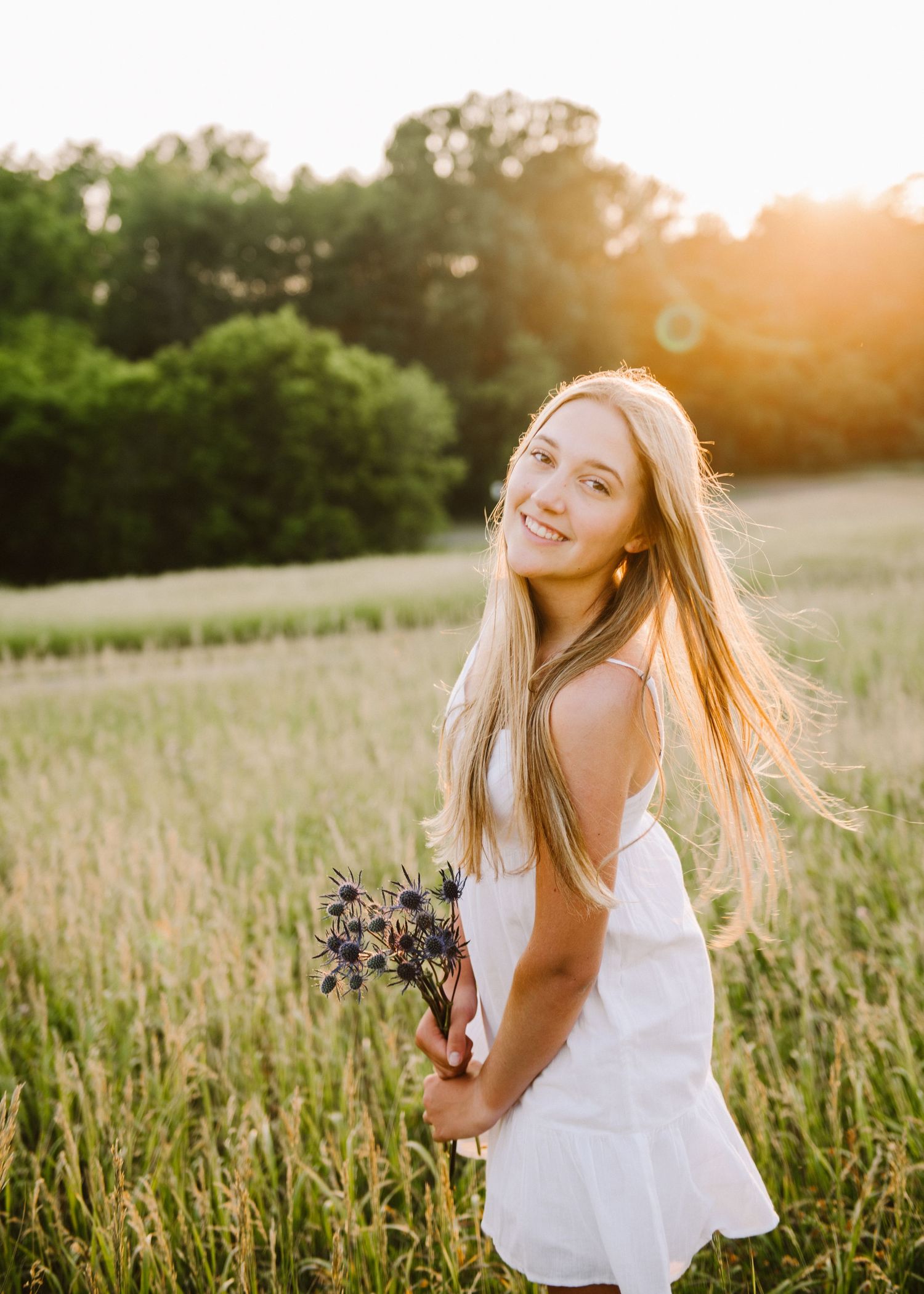 high school senior girl pictures in a field with flower bouquet