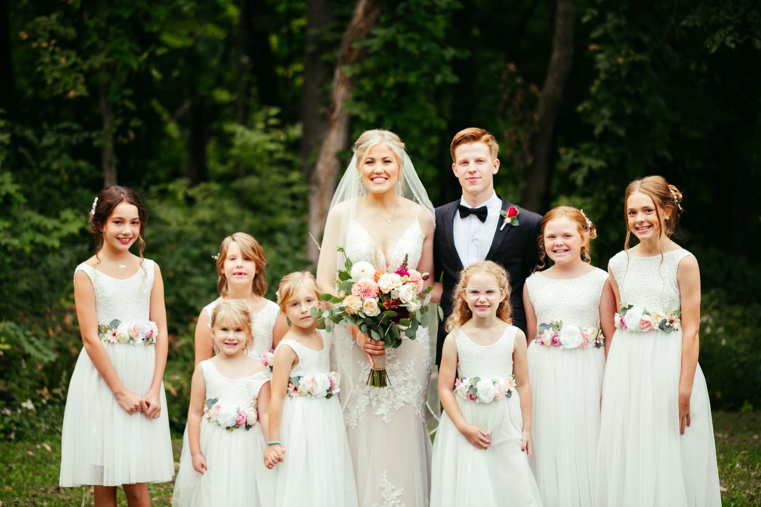 bride and groom picture with flower girls