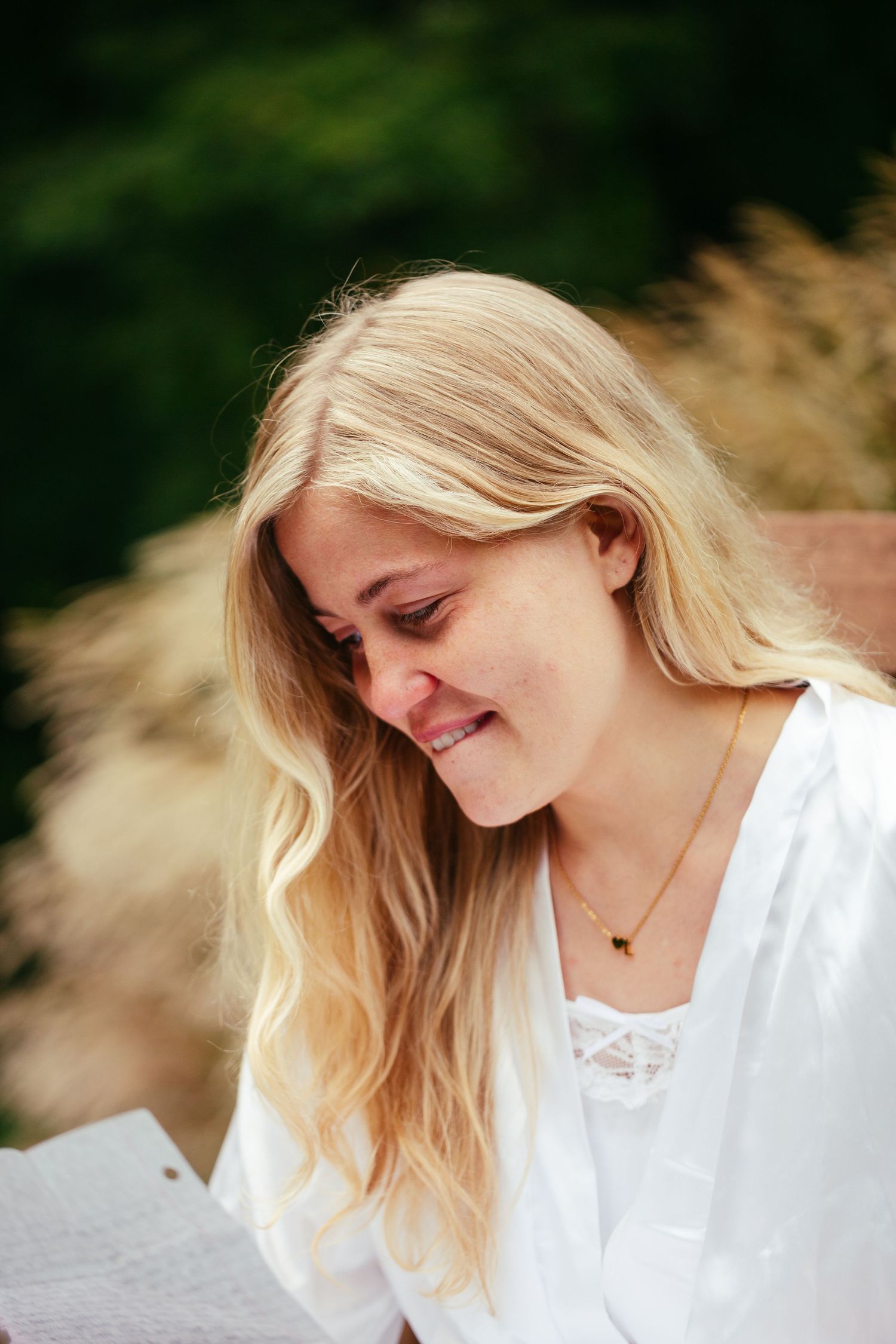 bride sitting in chair reading a letter crying