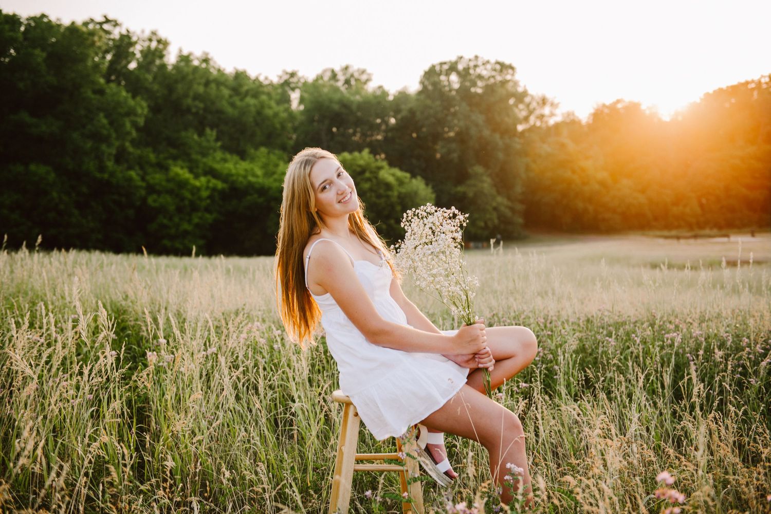 high school senior girl pictures in a field on a stool
