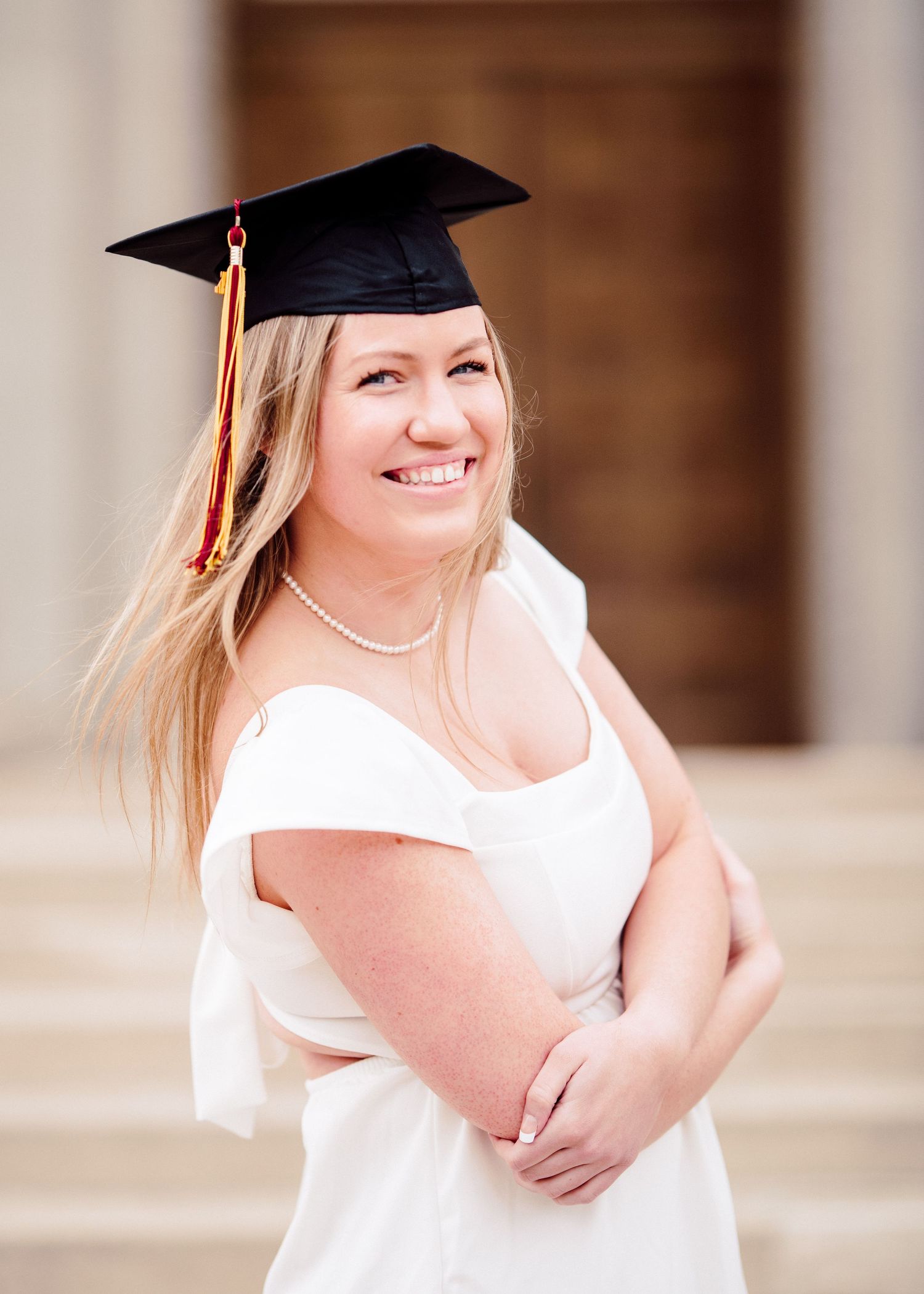 university of minnesota graduate in white dress with sash