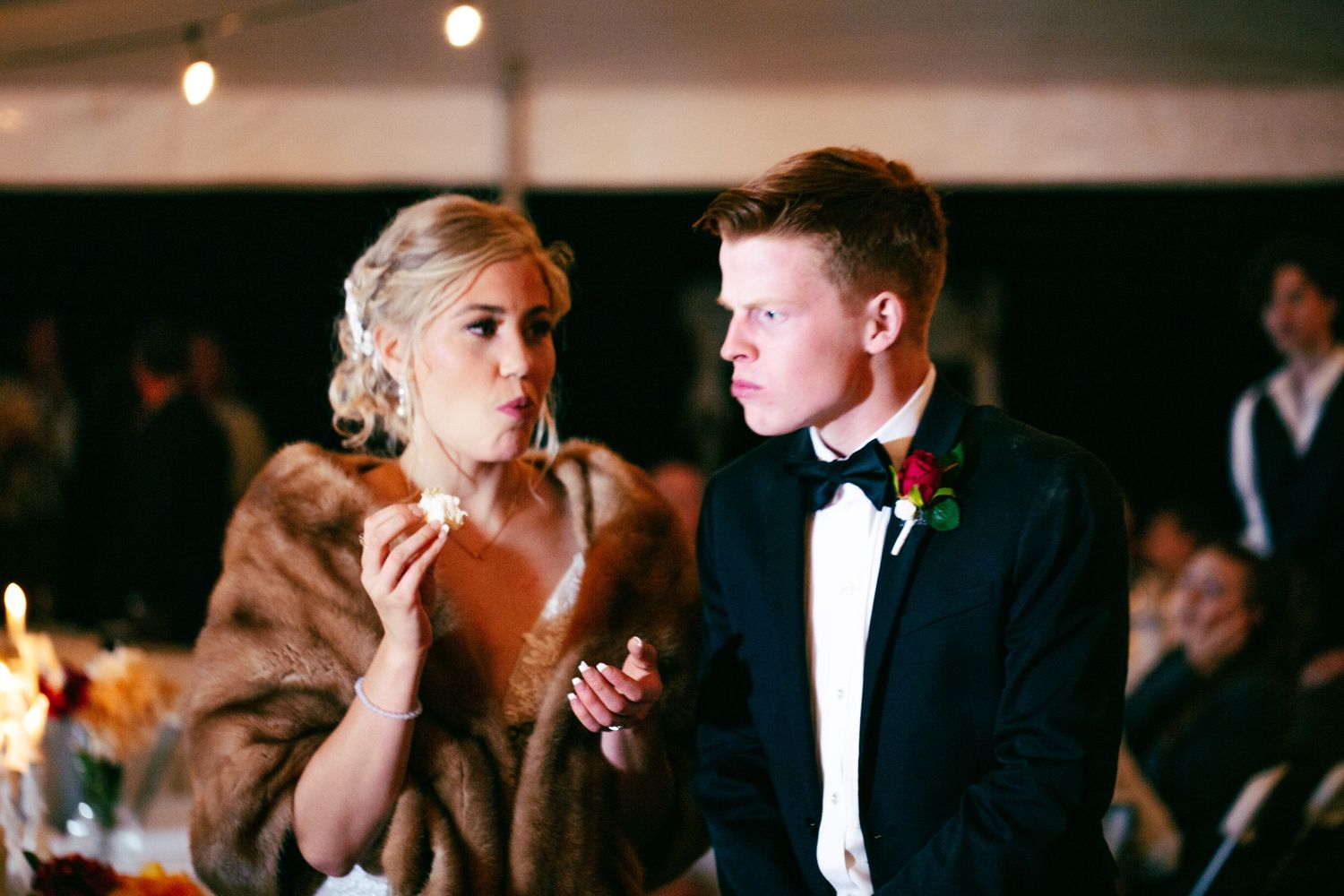 bride and groom cutting cake and taking first bite at wedding