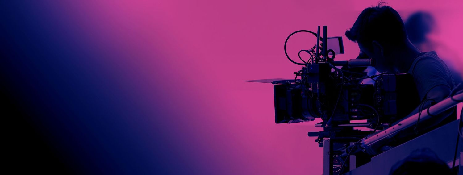 Professional video camera silhouette against a purple gradient background in a cinematic setup.