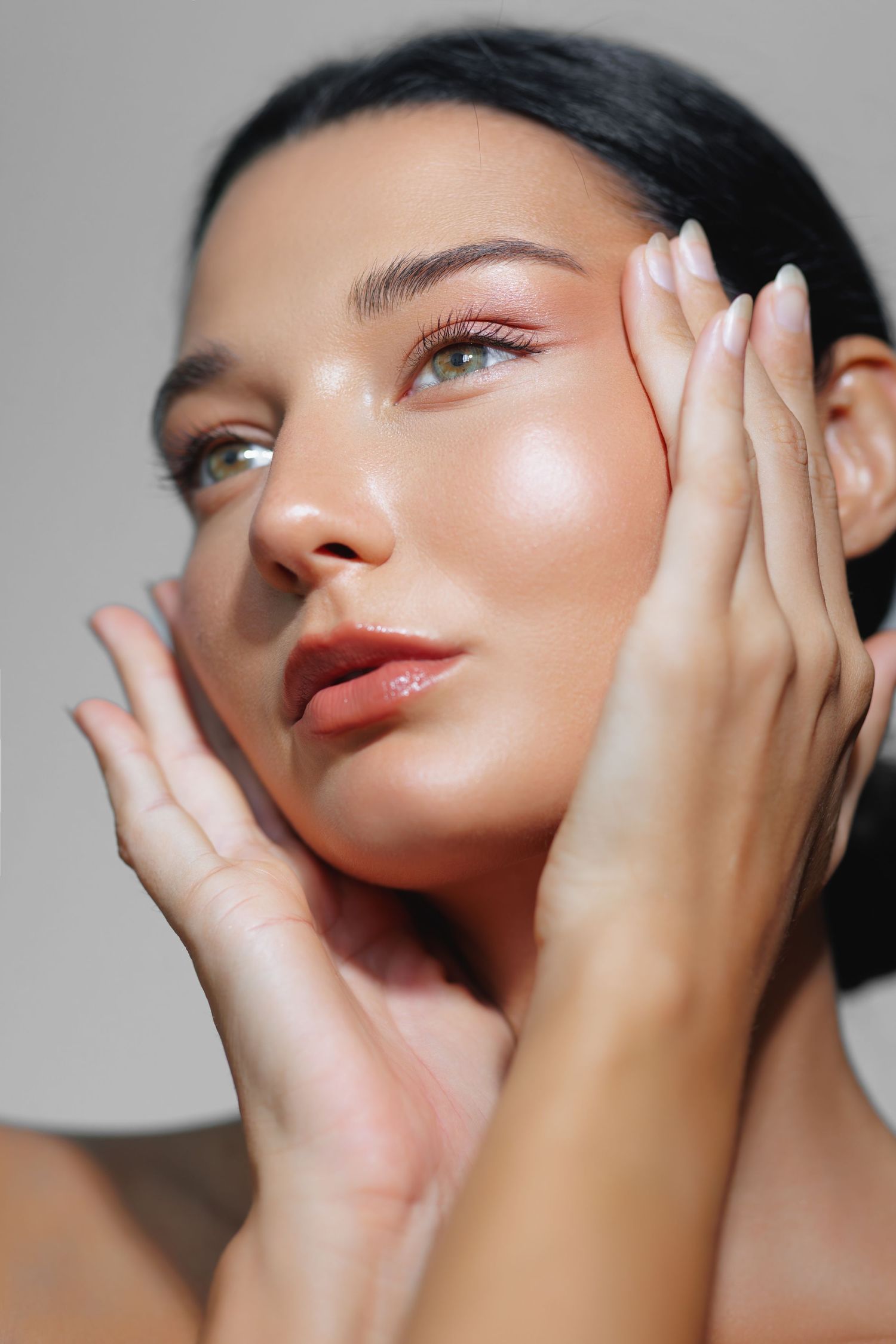 Close-up beauty shots showcasing glowing skin and glossy lips with hands framing the face in various angles.