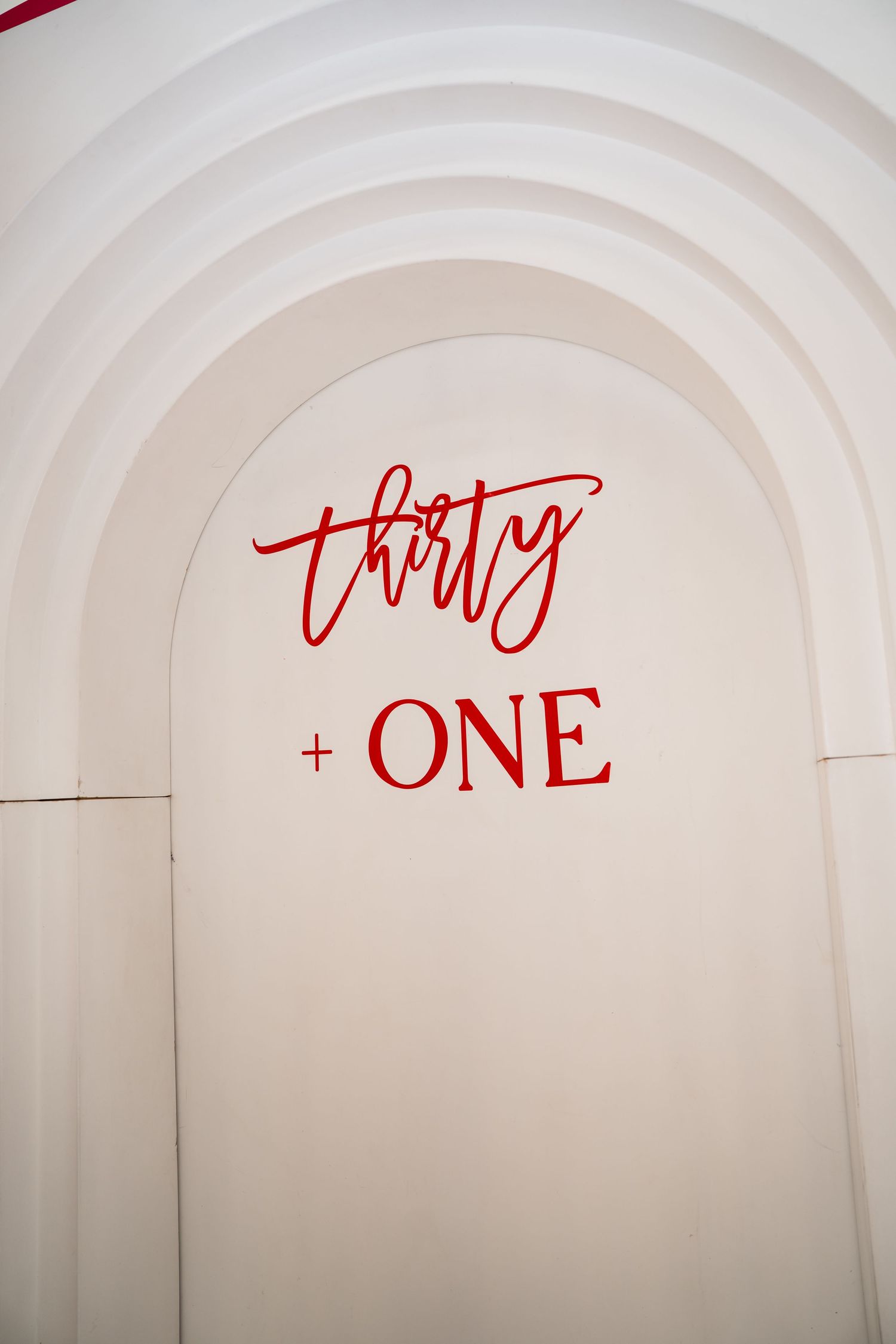 White arch backdrop with red script 