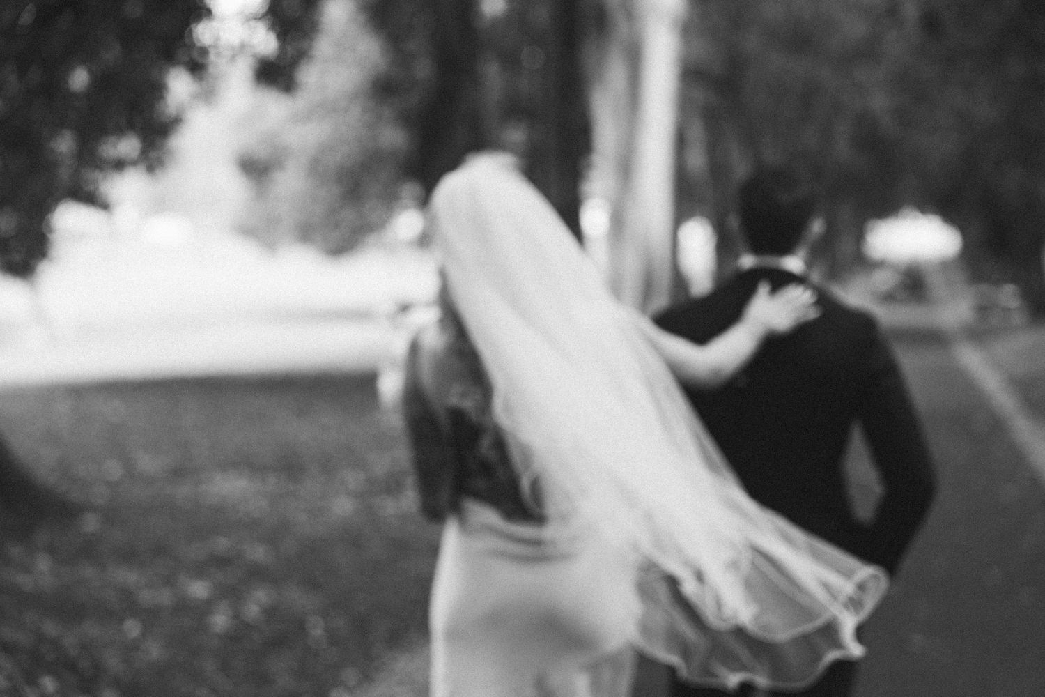 Elegant black and white wedding photos showing intimate moments between newlyweds outdoors.