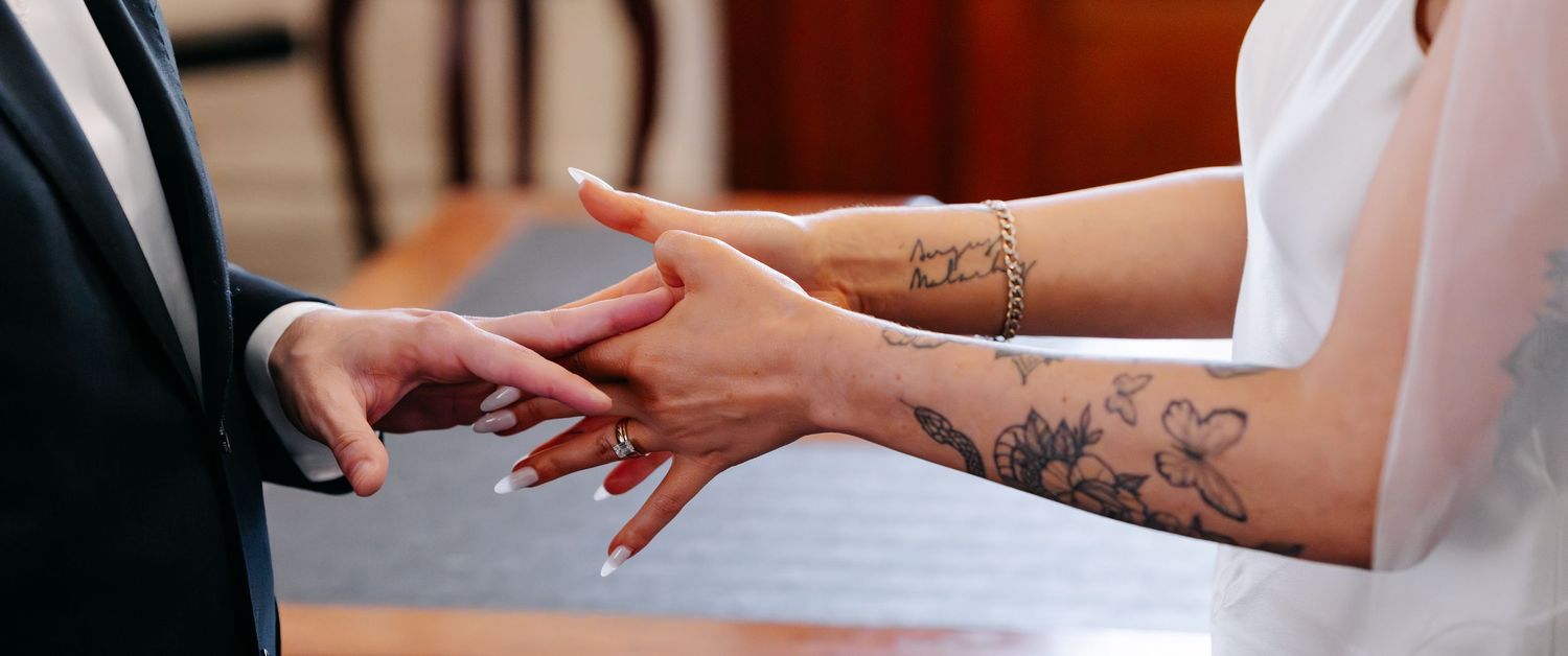 Artistic close-up shots of hands and wedding rings during ceremony.