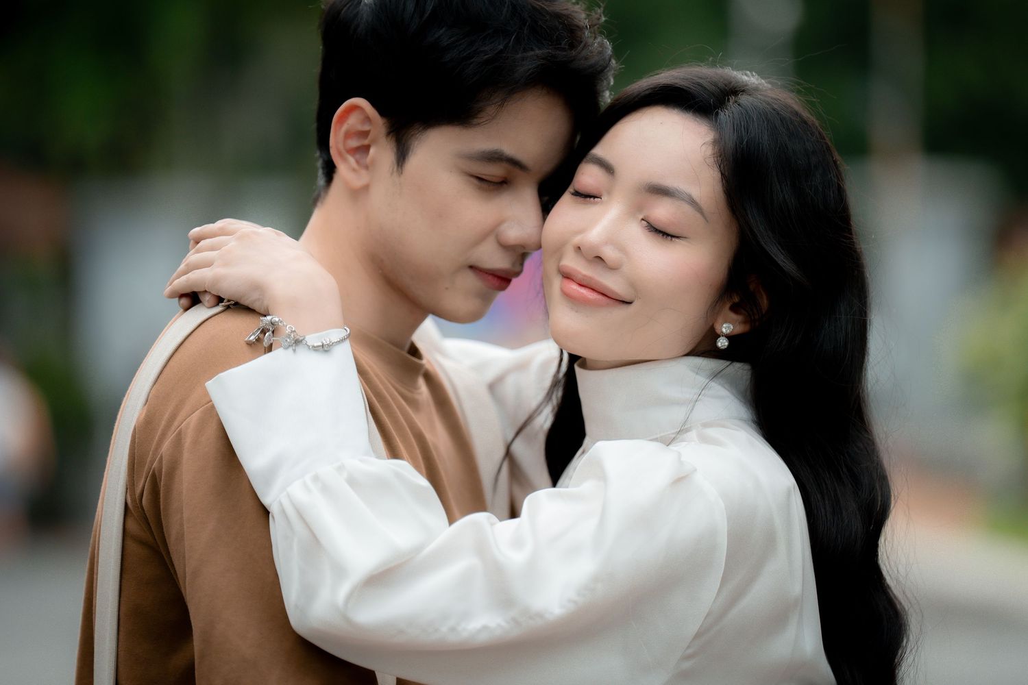 A couple shares romantic moments outdoors while wearing coordinated vintage-inspired outfits.