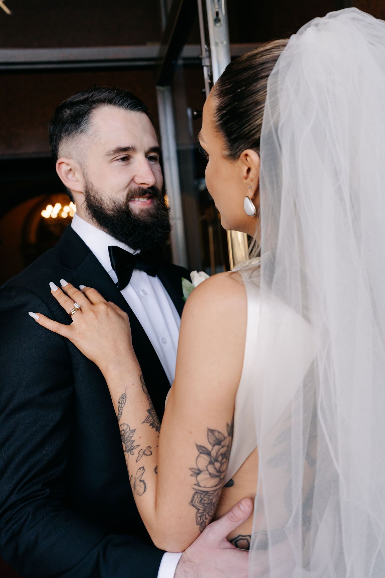 Intimate wedding portraits showing couple's tender moments and tattooed details.