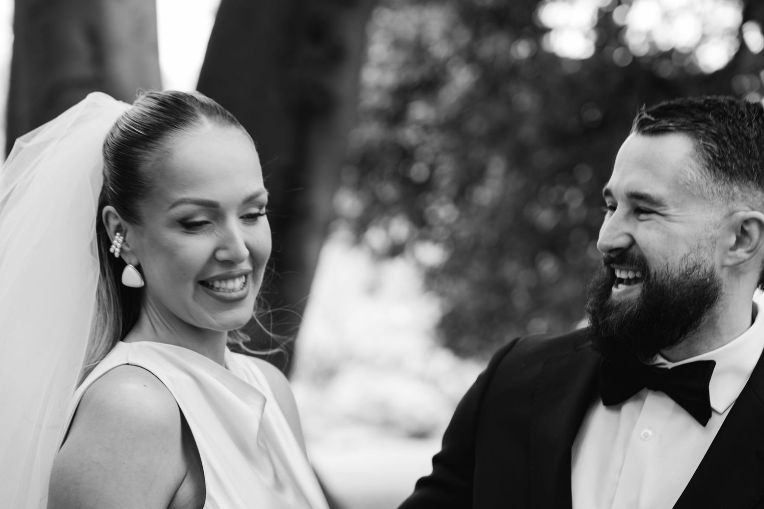 A romantic black and white wedding portrait showing a tender moment between the newlyweds.