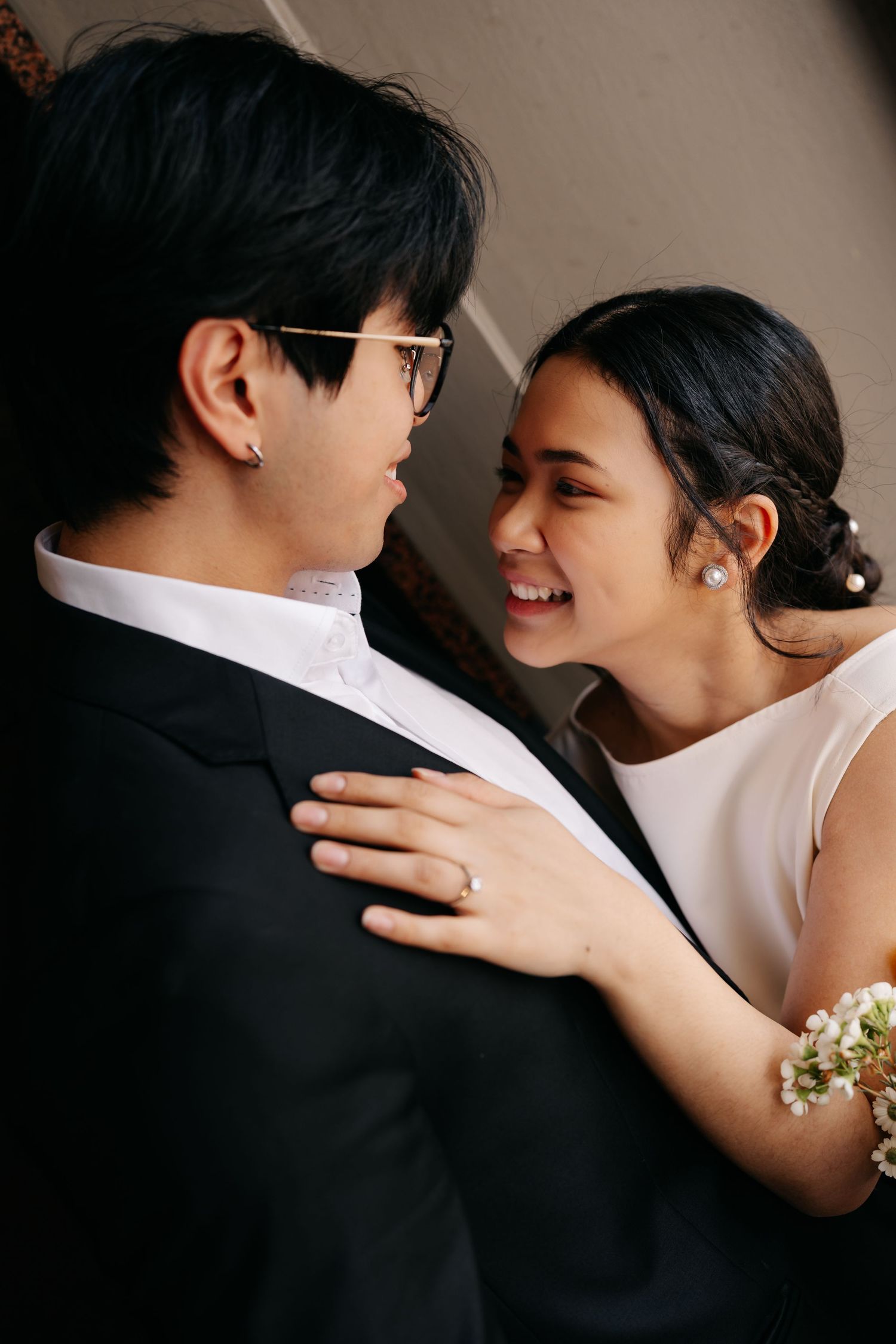 A tender moment between a couple in formal attire sharing a close embrace and joyful smile.