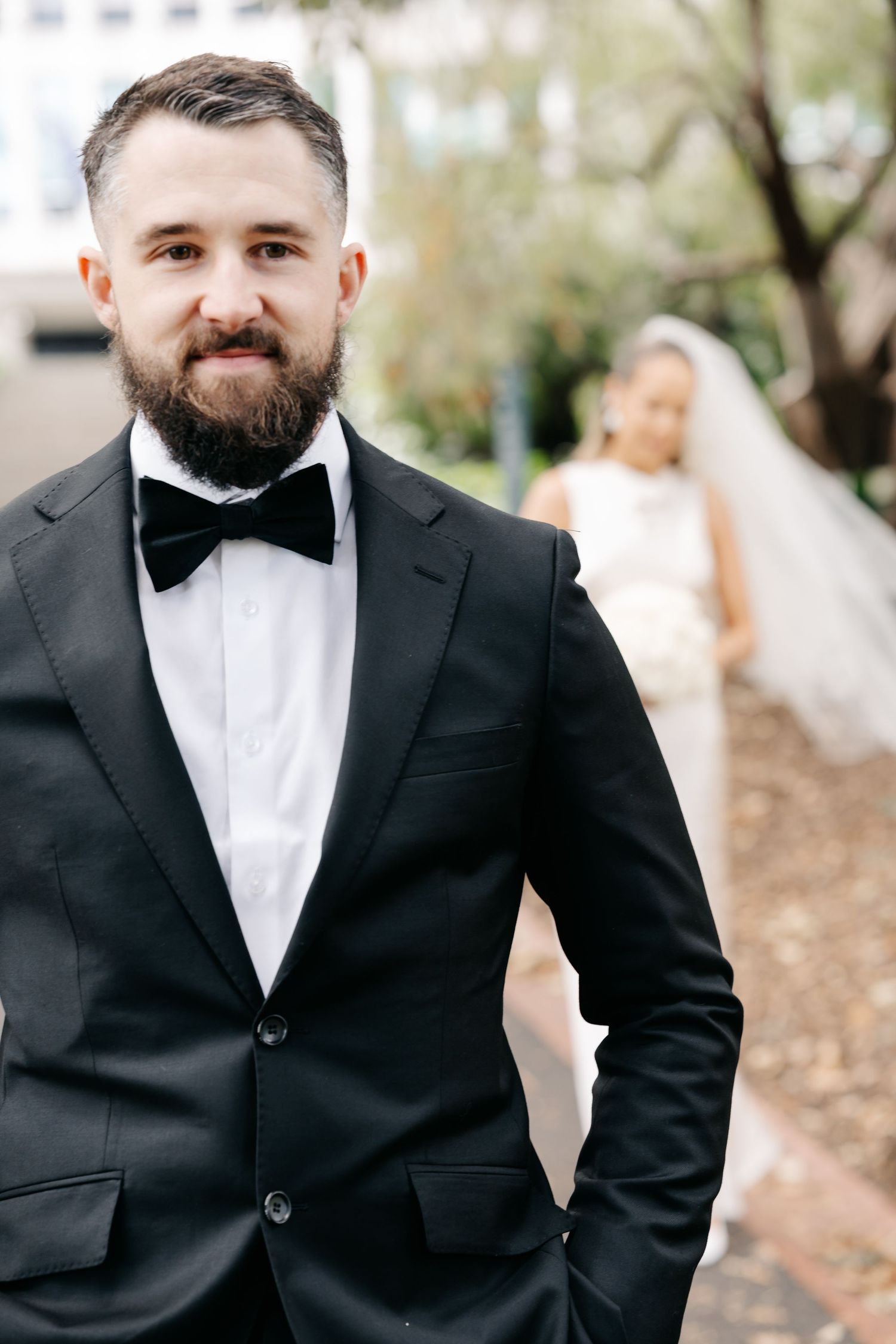 Groom in classic black tuxedo and bow tie shown in multiple angles.