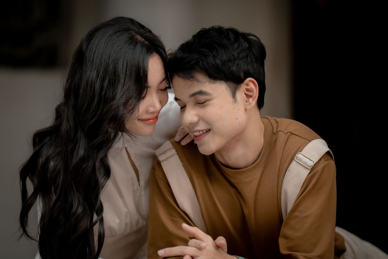 Romantic couple in brown and white outfits sharing intimate moments in a photo series.