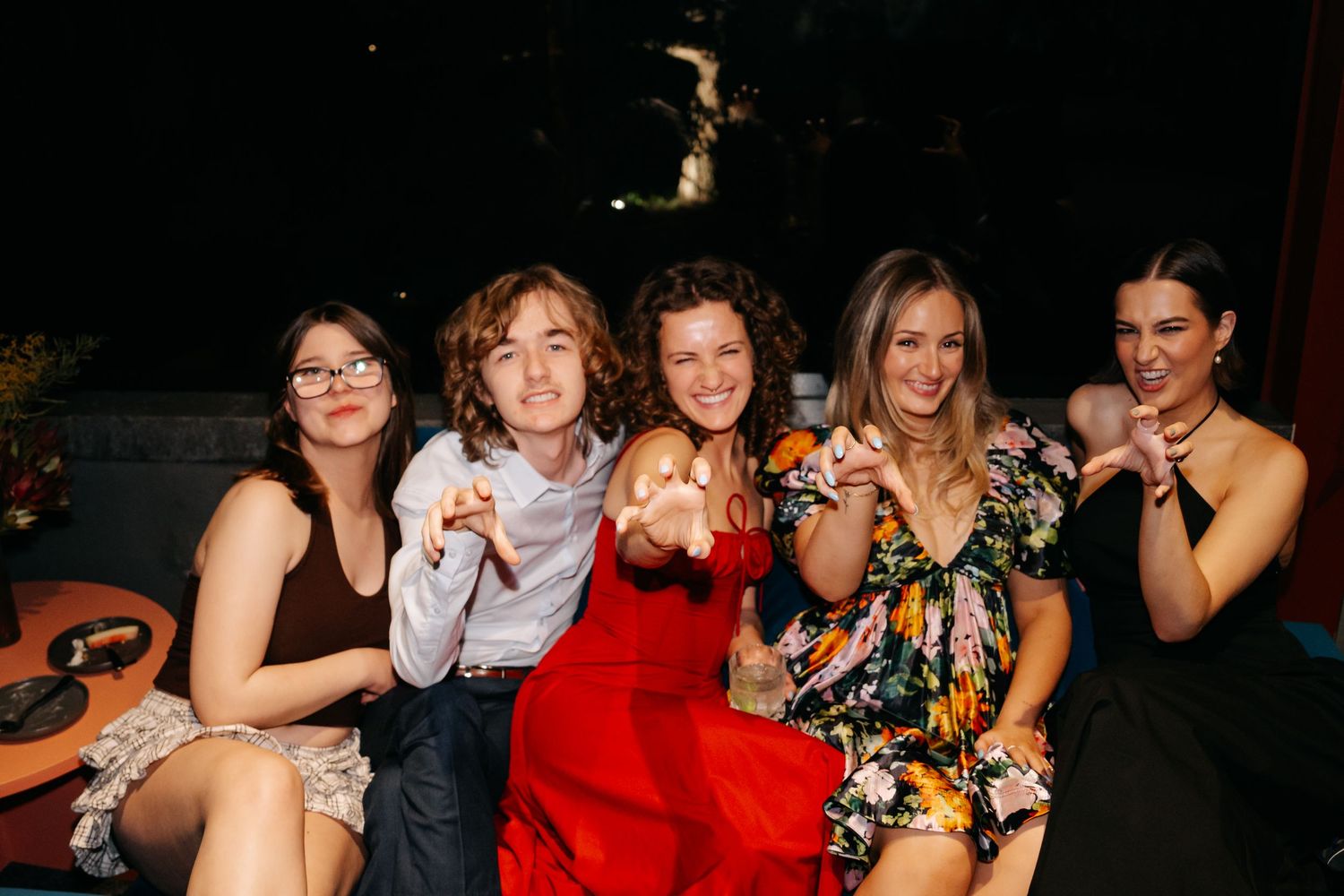 Group of friends posing together at nighttime outdoor party.