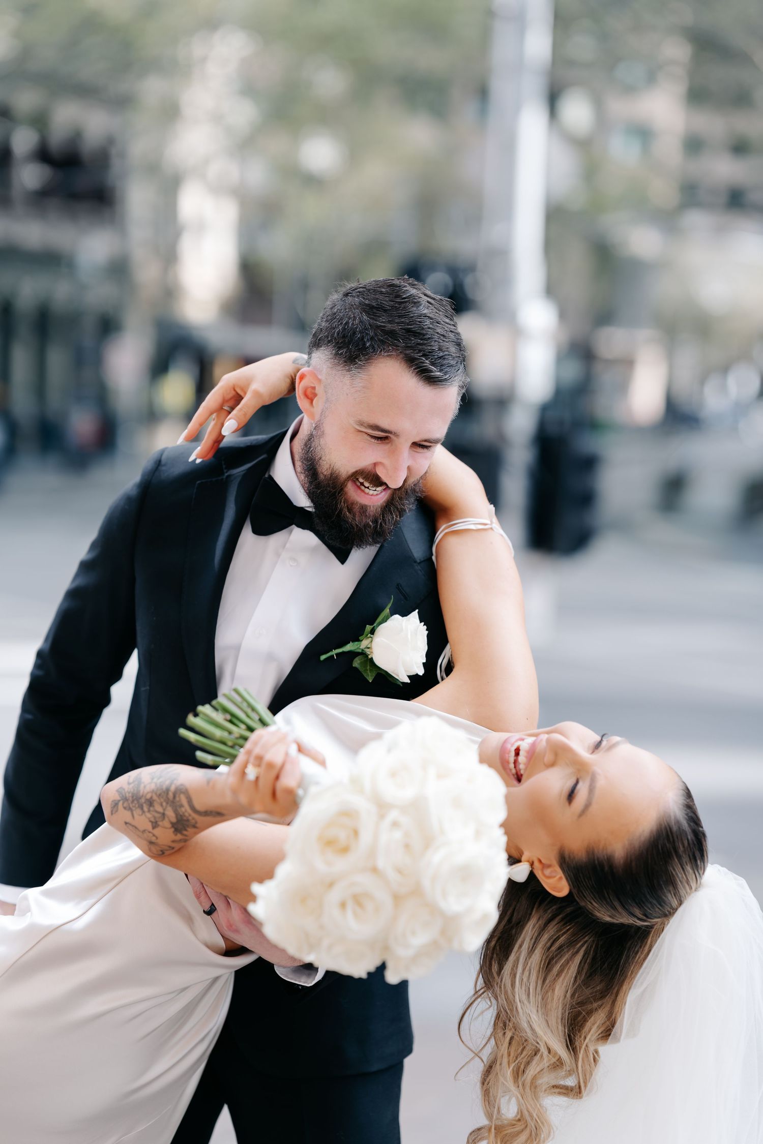 A romantic wedding photo sequence showing a couple in formal attire dancing and dipping in an urban setting.