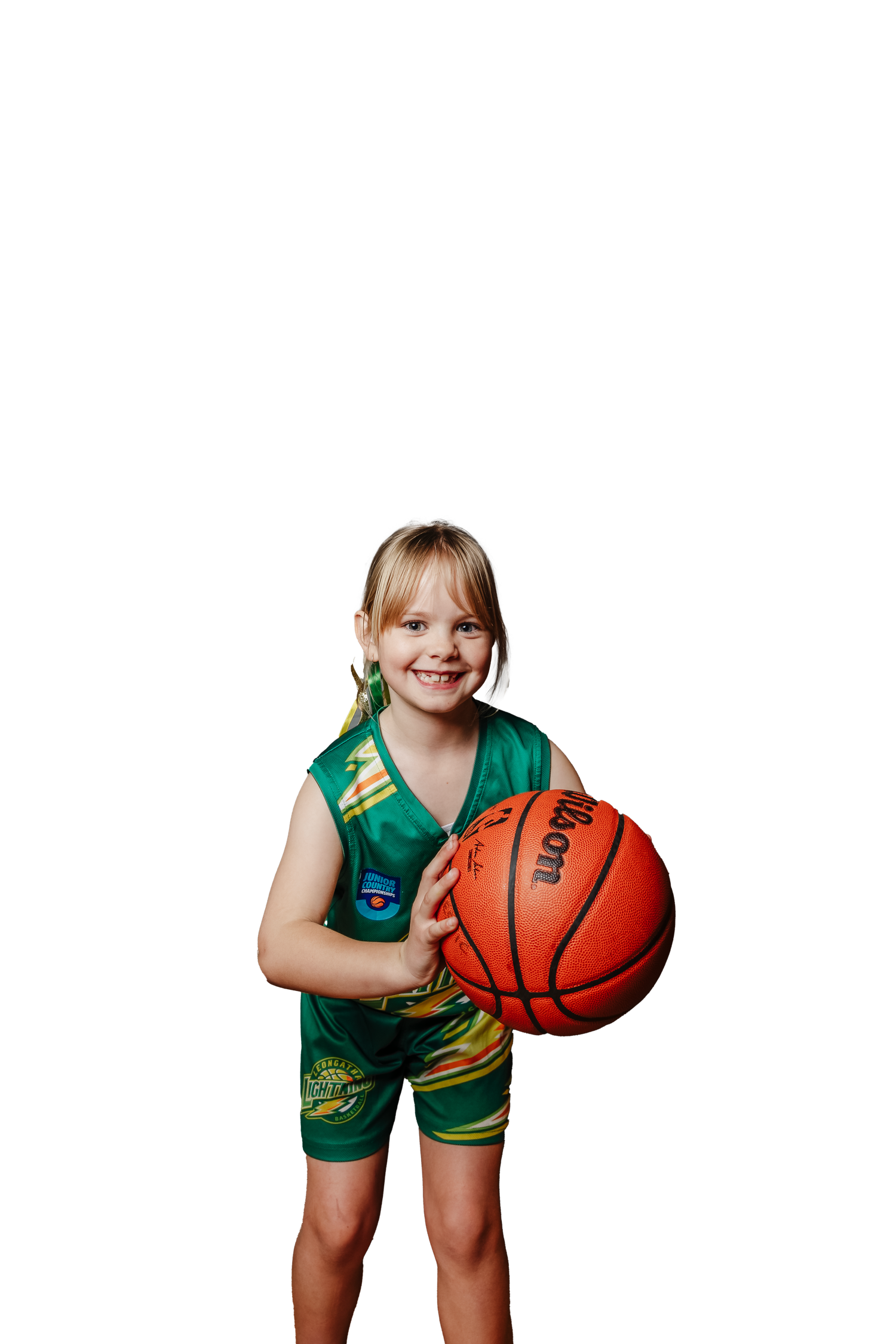 Young basketball player in green uniform holds orange basketball while posing for sports portrait series.