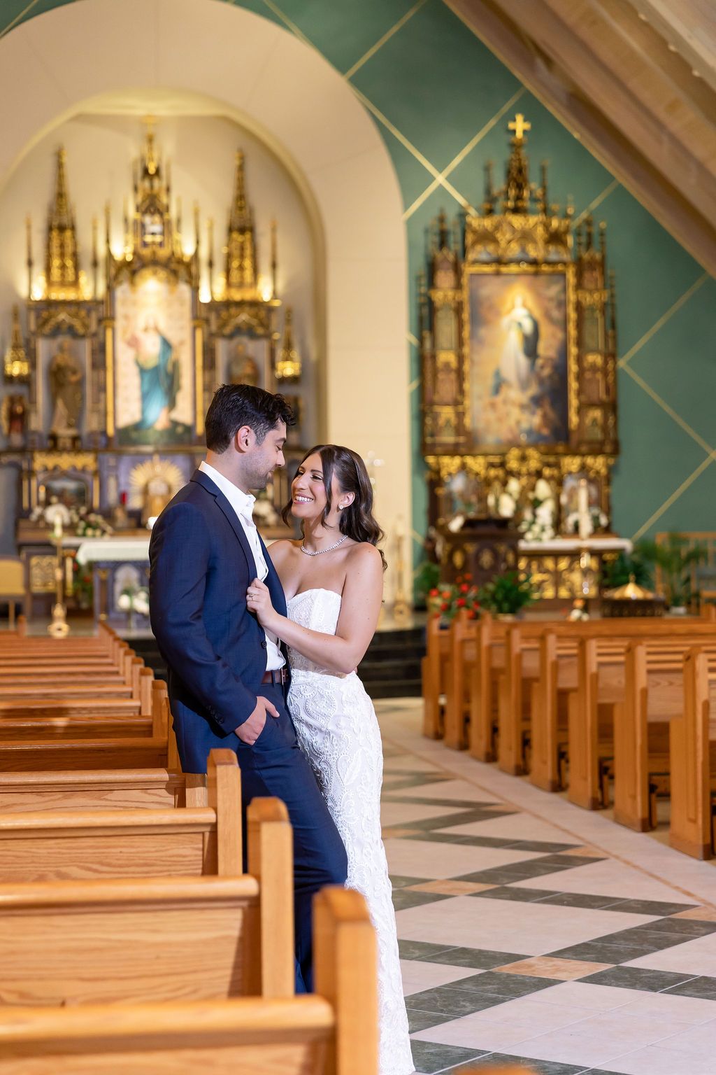 Wedding couple shares an intimate moment in a beautiful ornate church sanctuary.