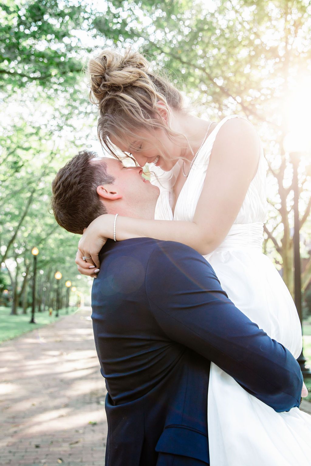 A romantic embrace captured in sunlit gardens with the couple in traditional wedding attire.