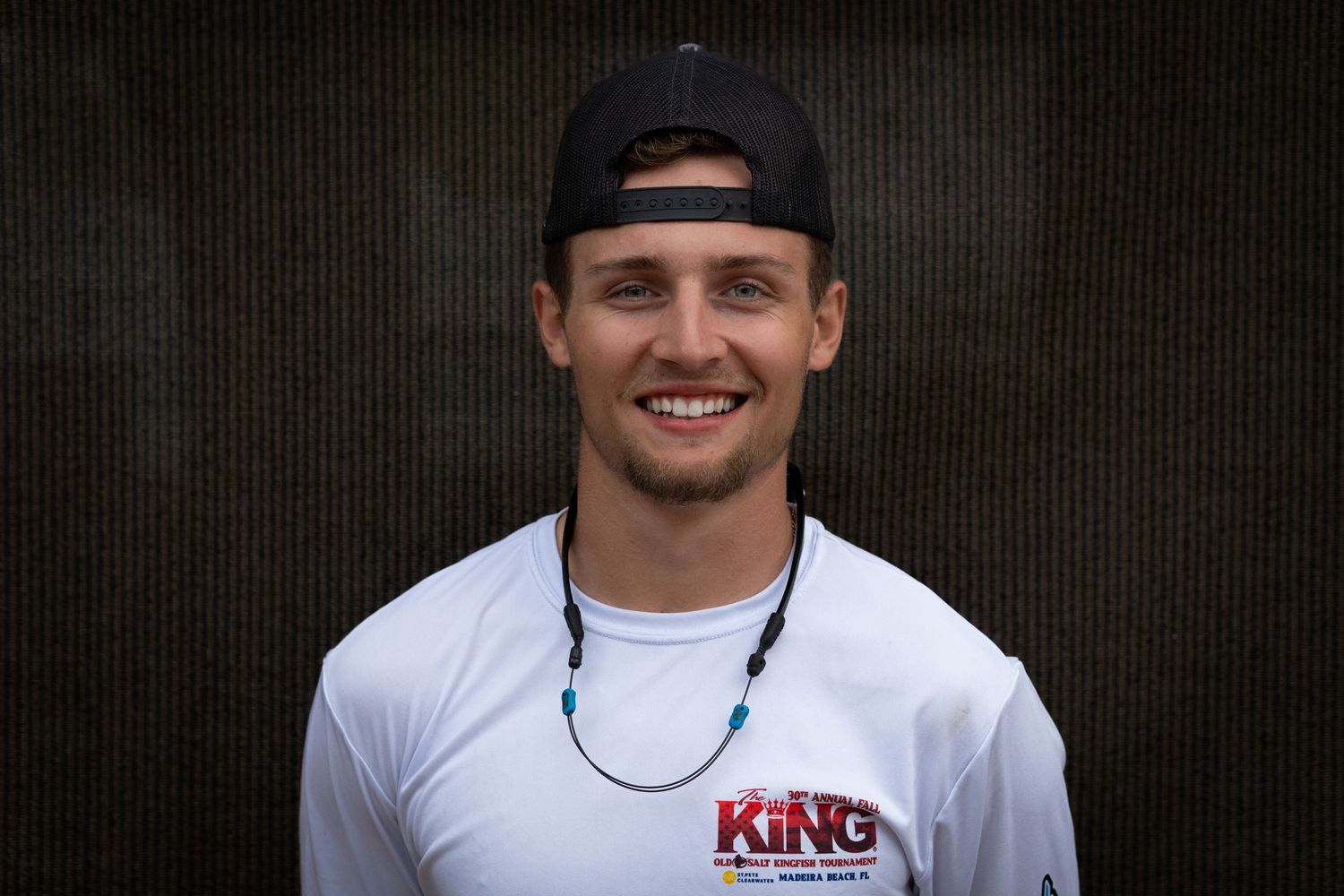Athletic portrait of young person in white t-shirt and baseball cap.