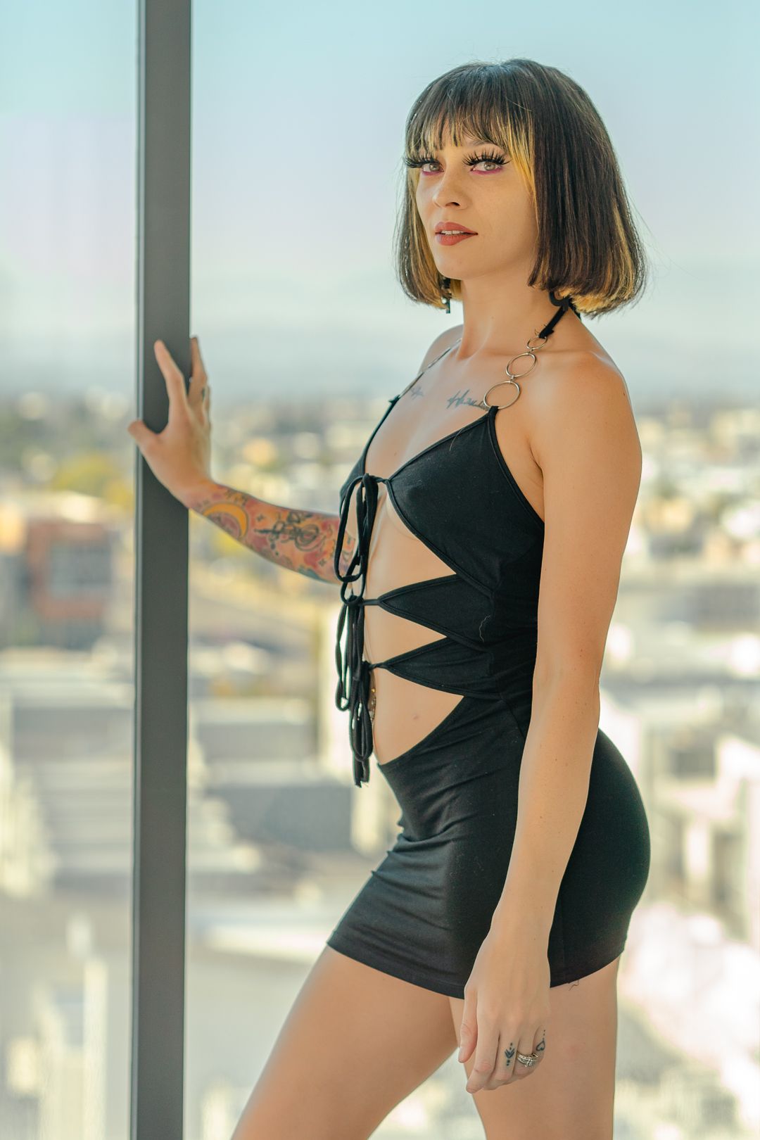 Urban fashion portrait with cityscape background through window.