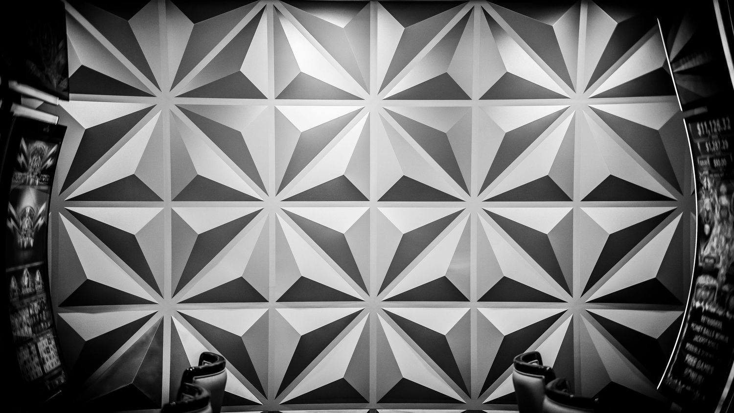 Black and white geometric ceiling pattern with repeating star-shaped modular panels creating a striking modern design.