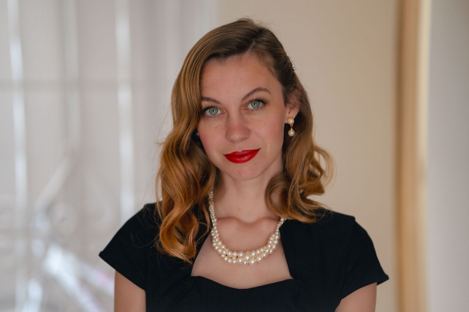 Classic beauty portrait with styled waves, red lips and pearl necklace.