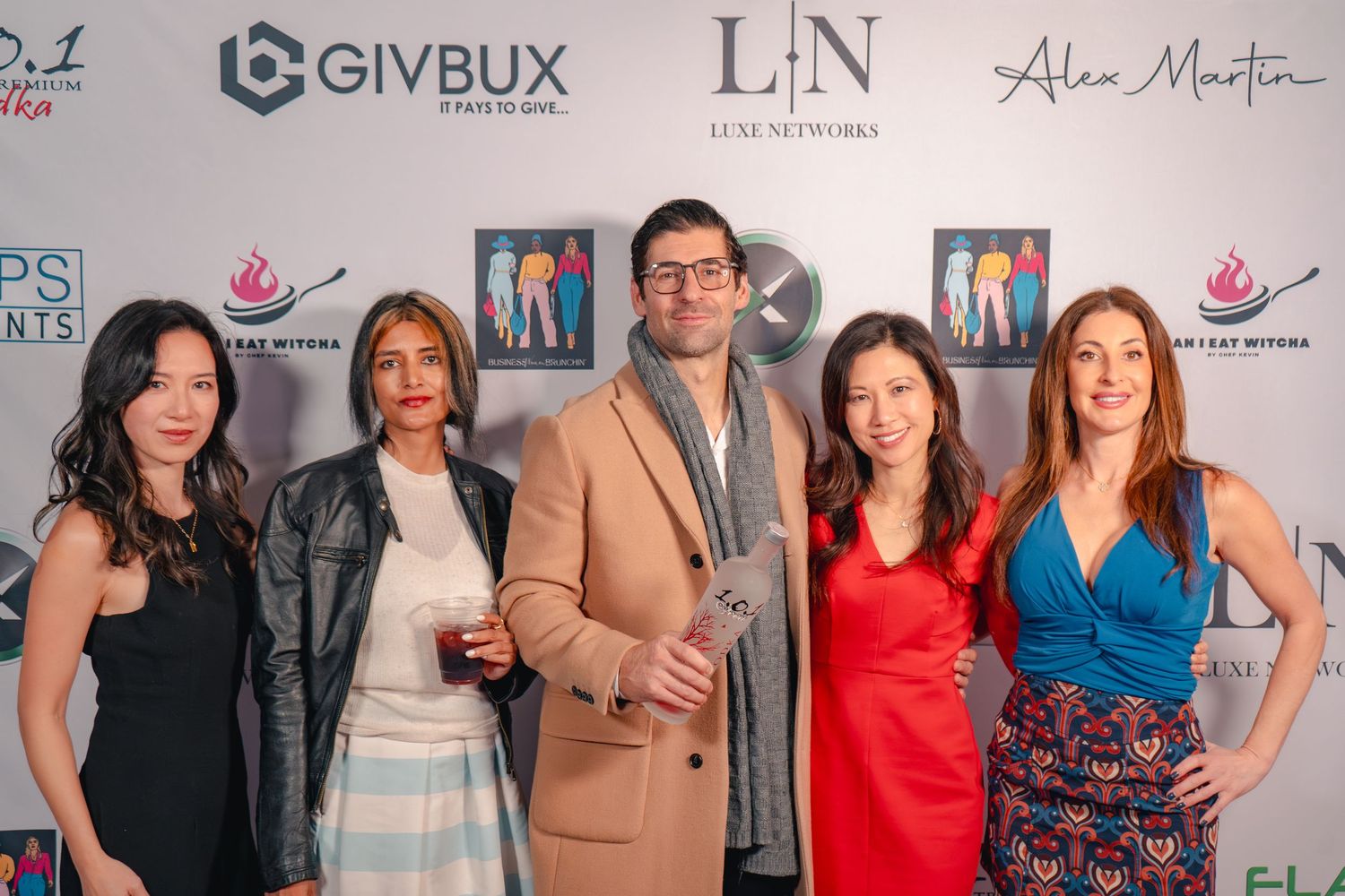 A group poses in front of a branded event backdrop with company logos including Givbux and LIN.