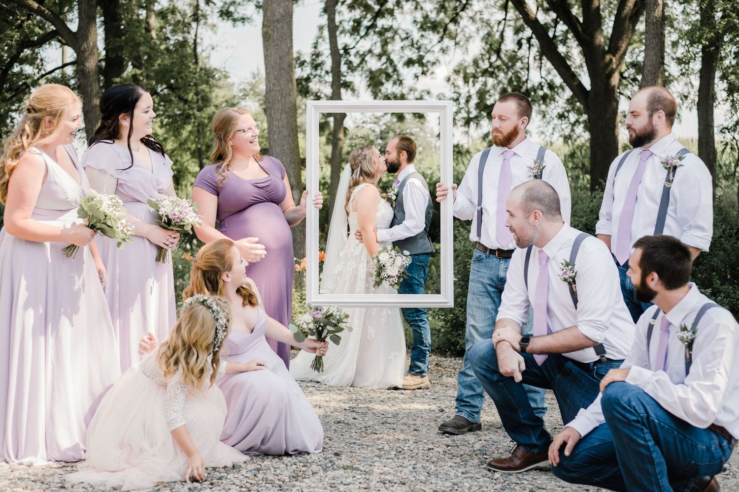 wedding party photo holding frame in front of bride and groom fun an unique