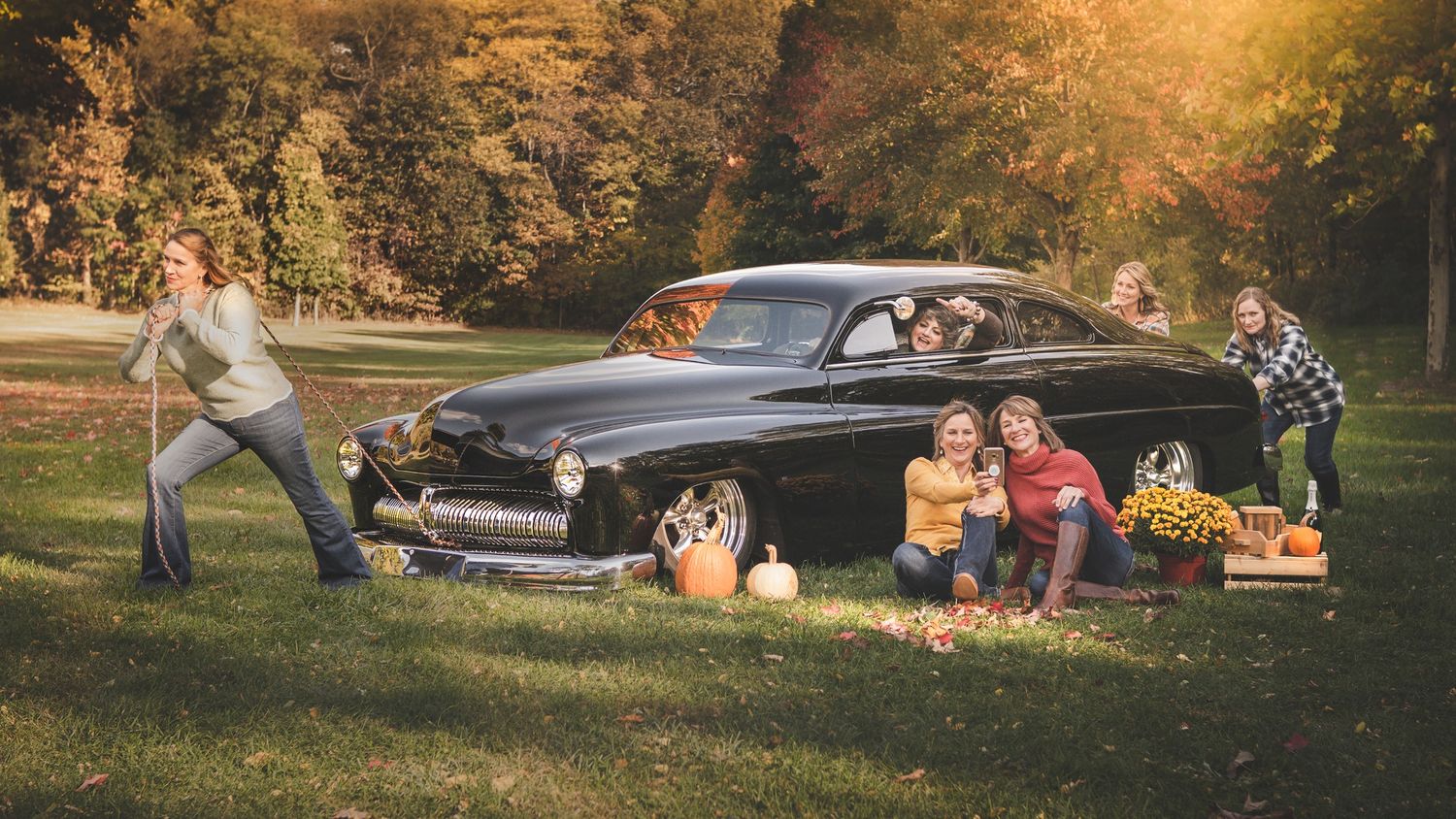 funny photo of sisters with oldsmobile old black car in the fall autumn