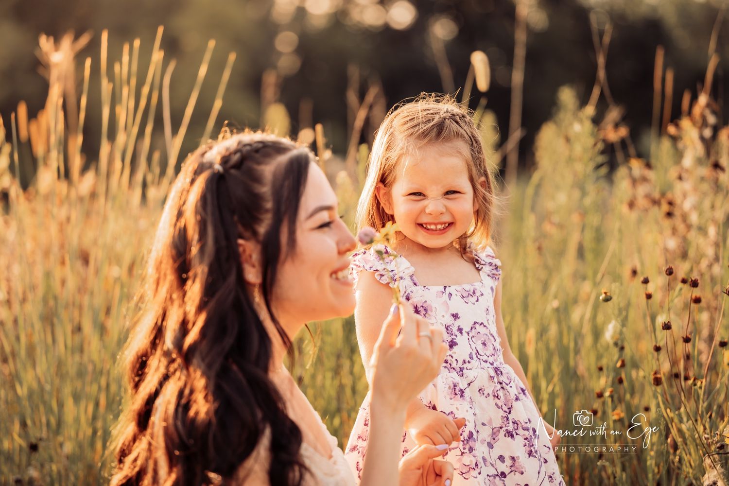 mother and toddler daughter  in field daughter smiles