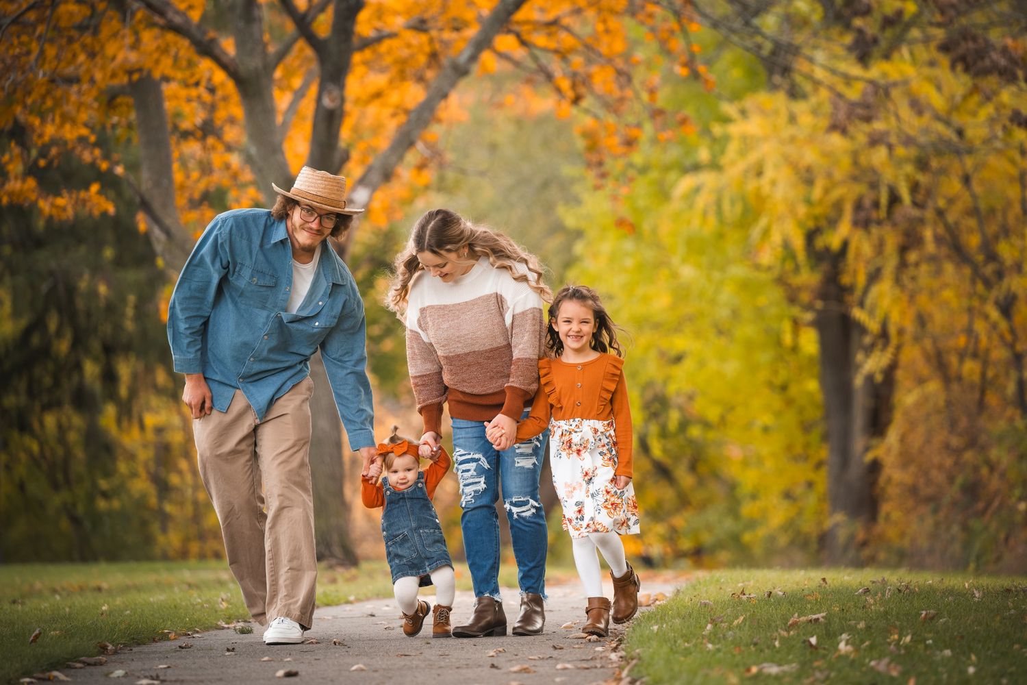 family of four photoshoot in the fall walking down a path