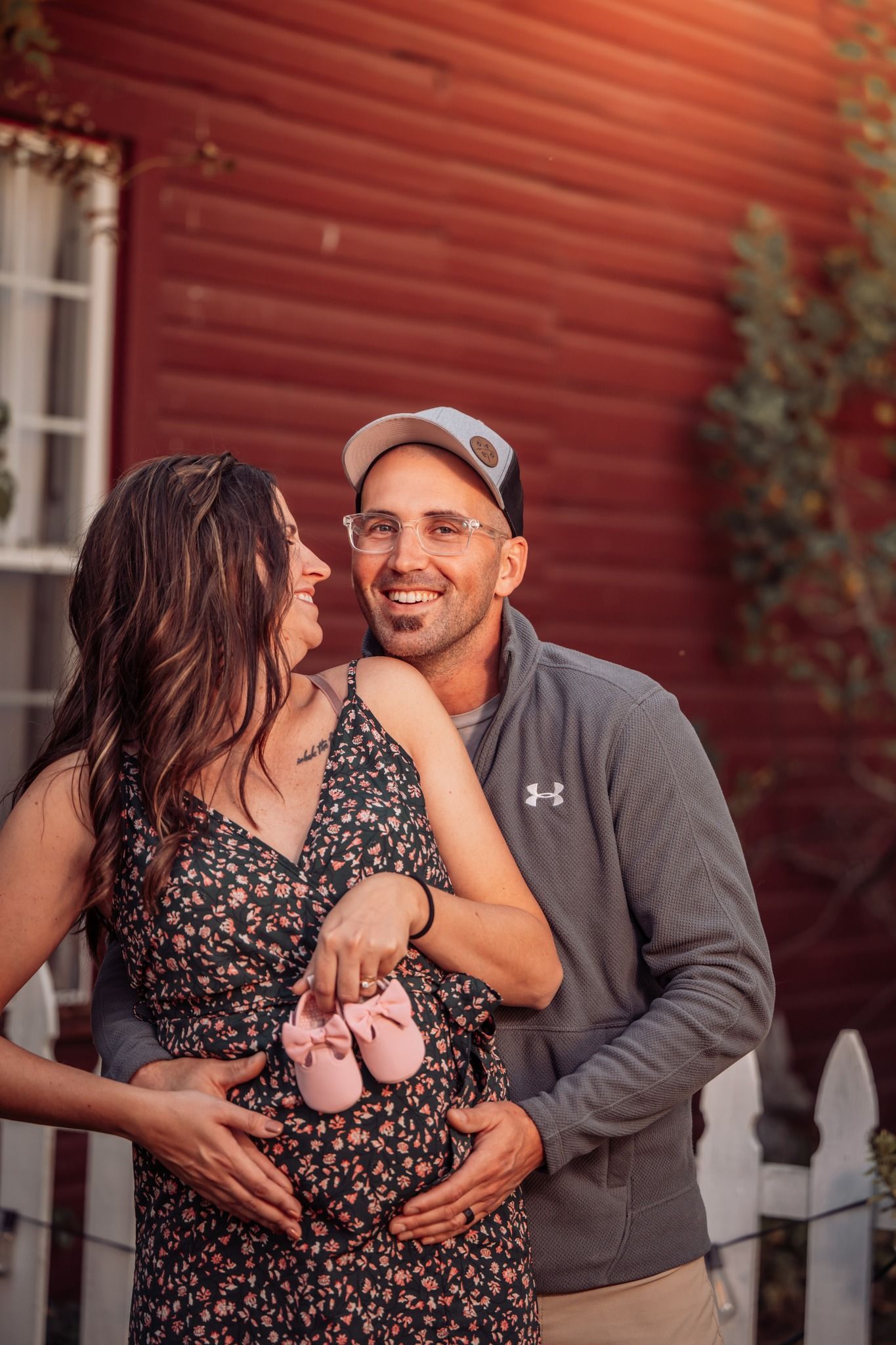cute couple maternity photoshoot holding baby shoes